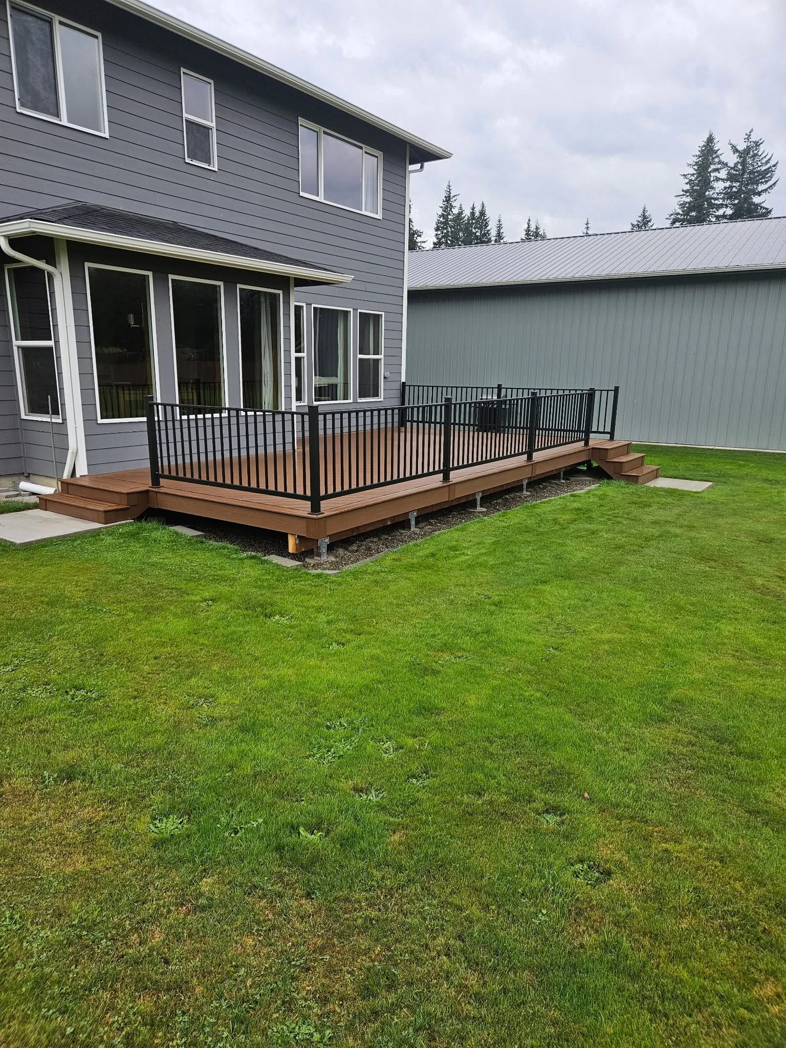 Residential outdoor deck with custom-fabricated black metal railing system.