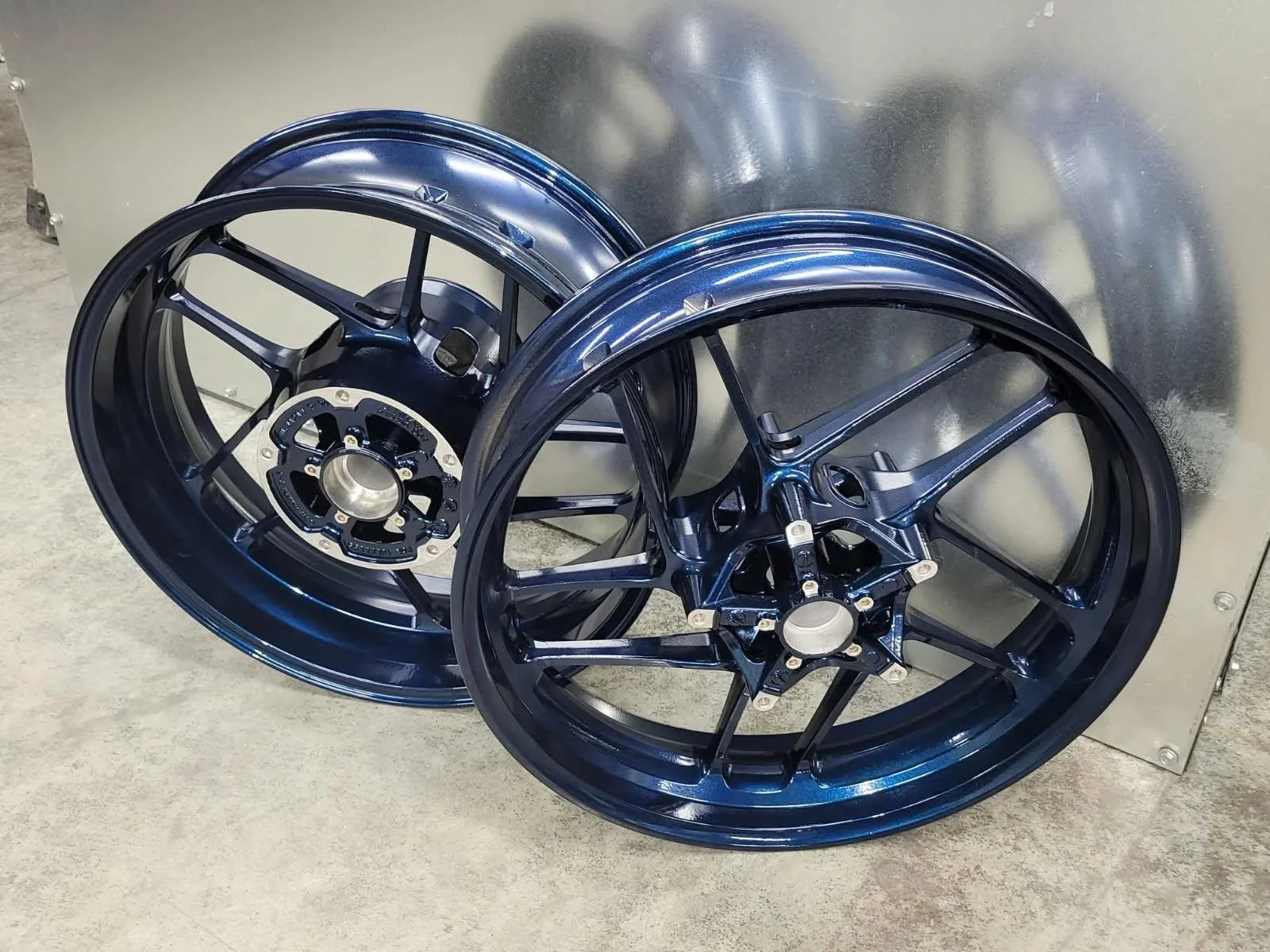 Pair of motorcycle wheels with a custom high-gloss blue industrial powder-coated finish.