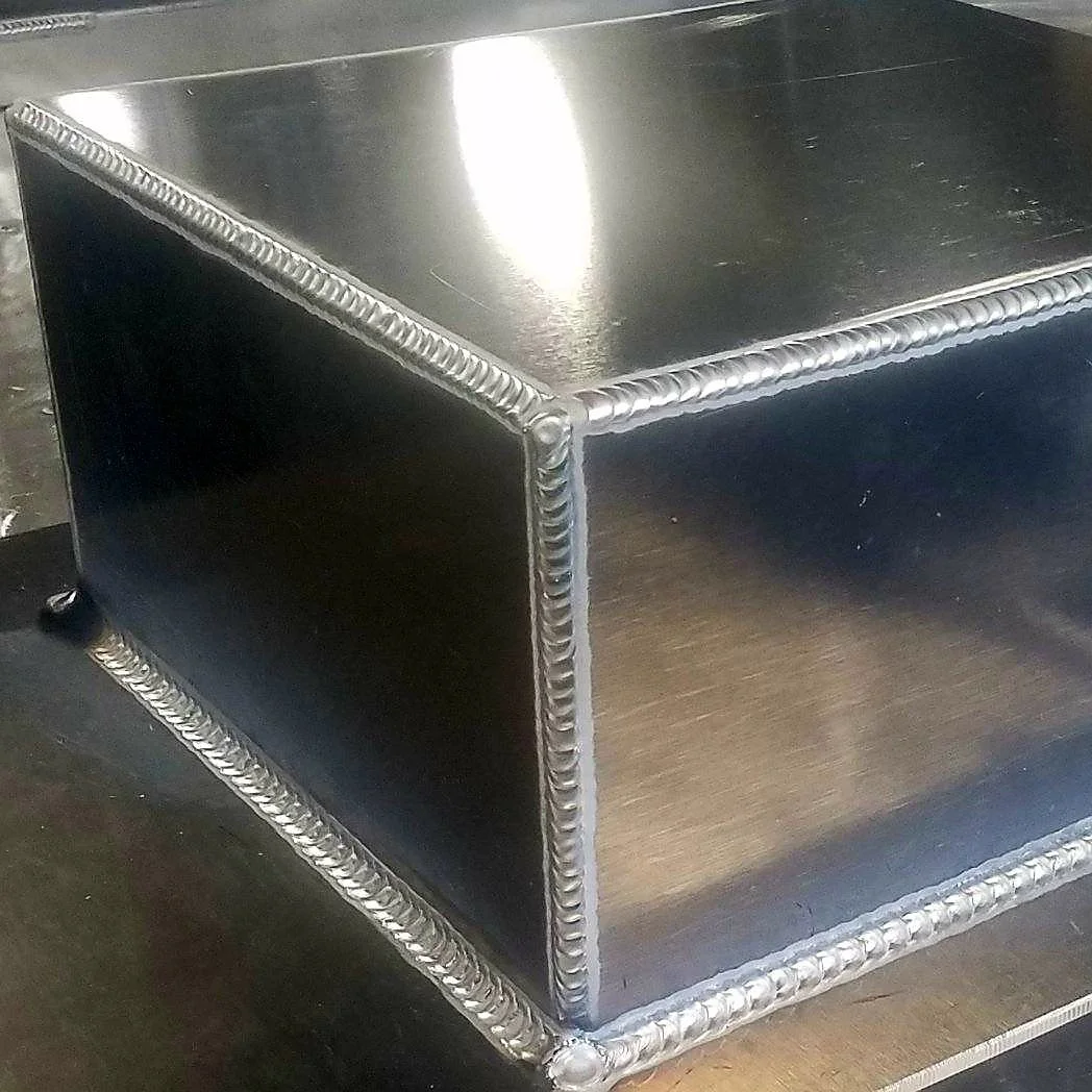 Close-up of a high-quality MIG-welded aluminum corner seam on a custom fabrication project.