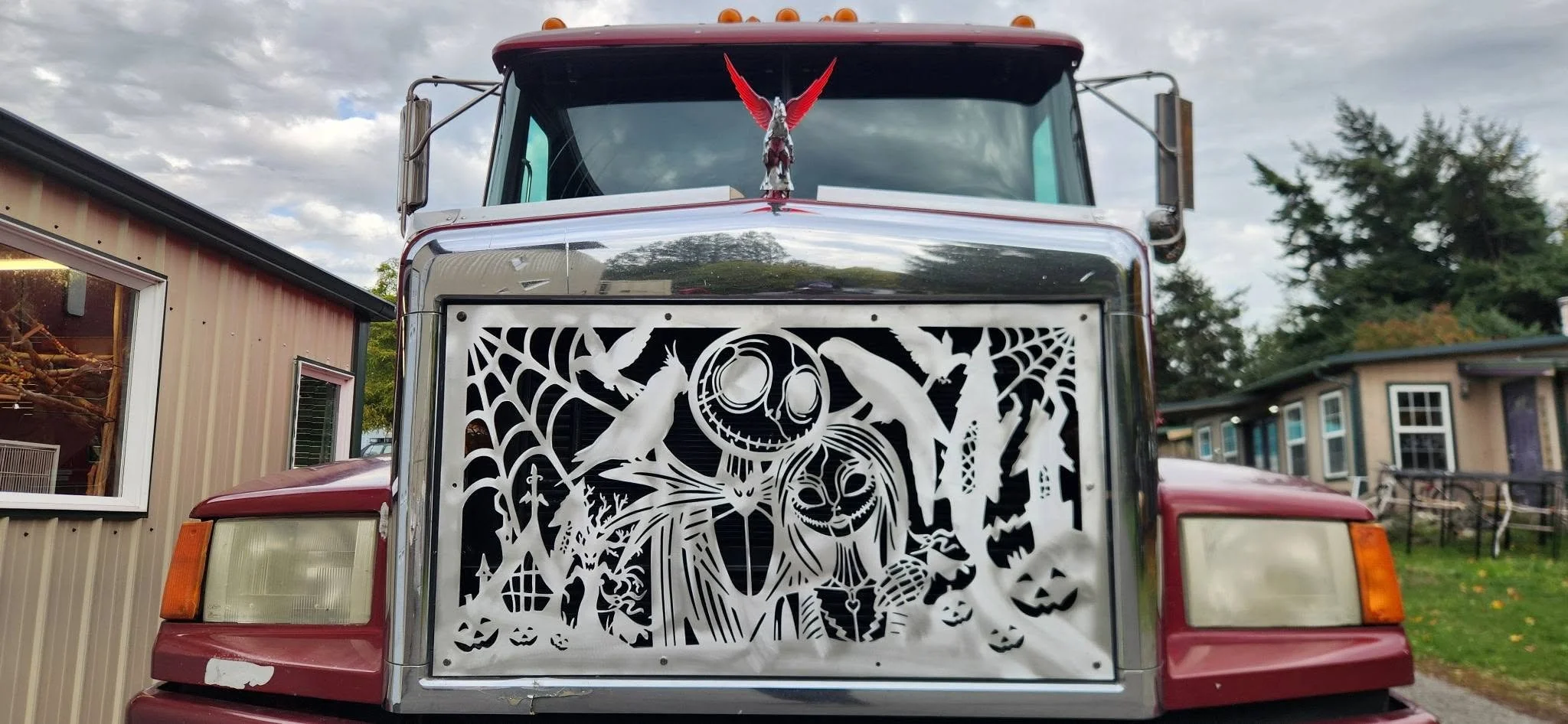 Custom-fabricated metal semi-truck grille insert featuring intricate CNC-cut holiday character artwork.
