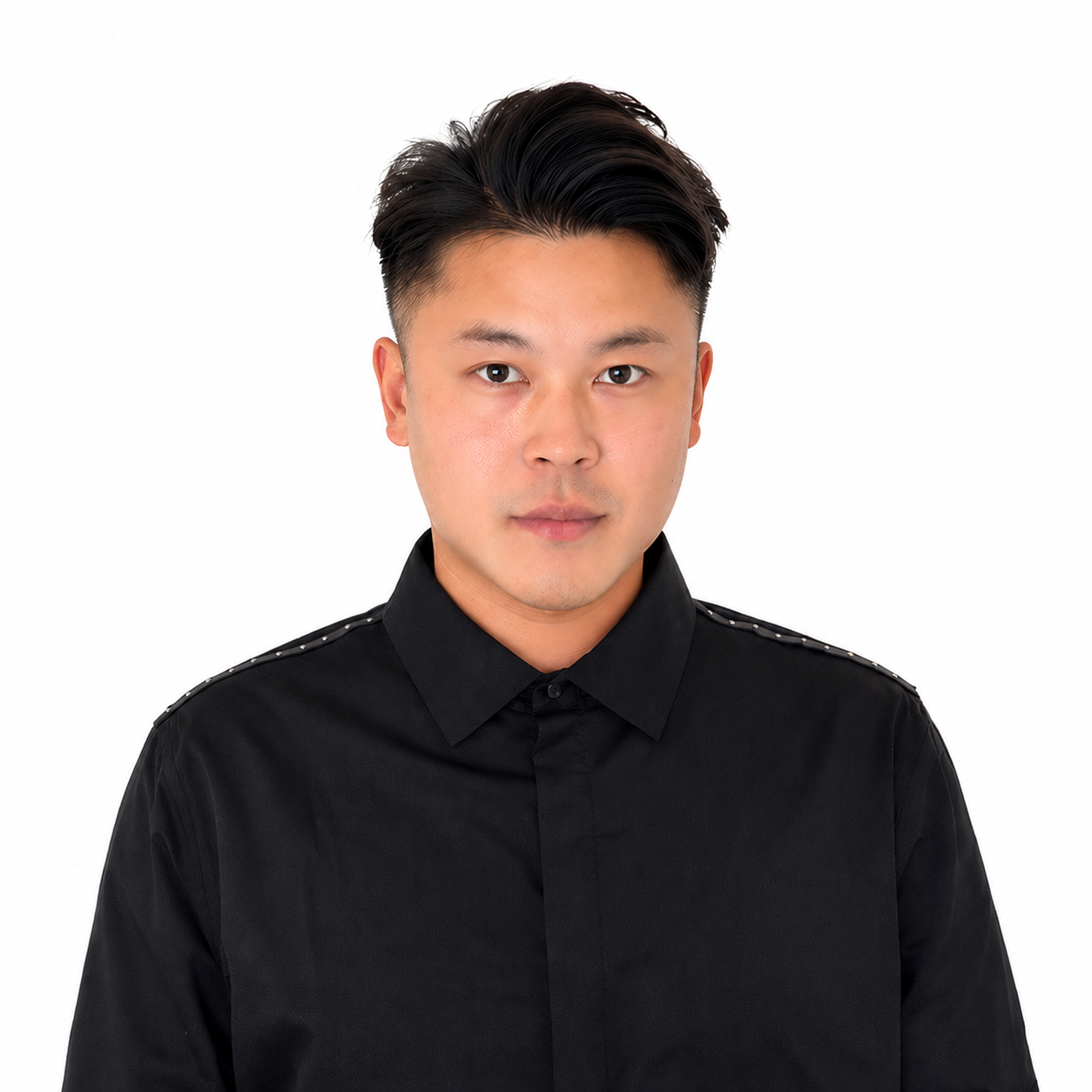 Headshot of a young Asian man with black hair wearing a black shirt with shoulder embellishments, looking directly at the camera against a white background.
