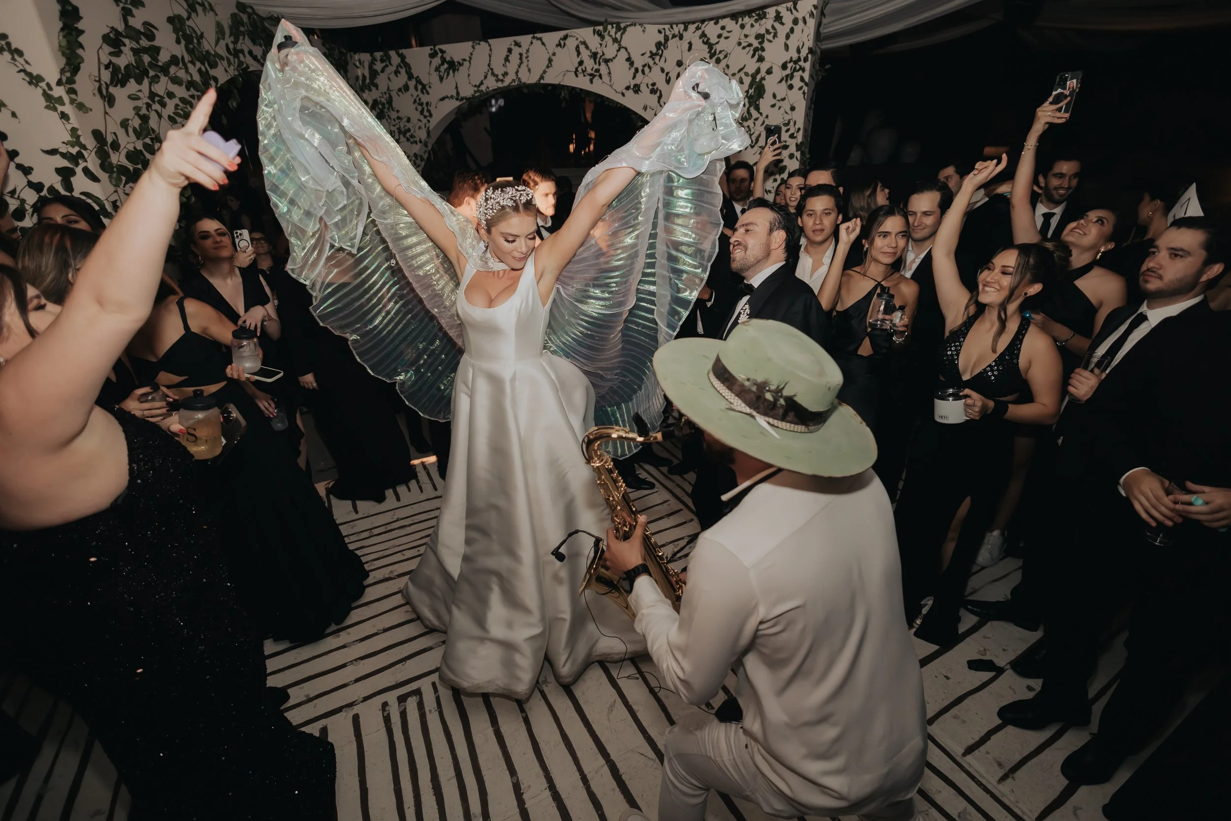 novia feliz en dandolo todo en el dia de su boda acompañada de la mejor musica de sax para bodas por Tato Venegas. boda top de lujo, invitados brincando de felicidad y energia