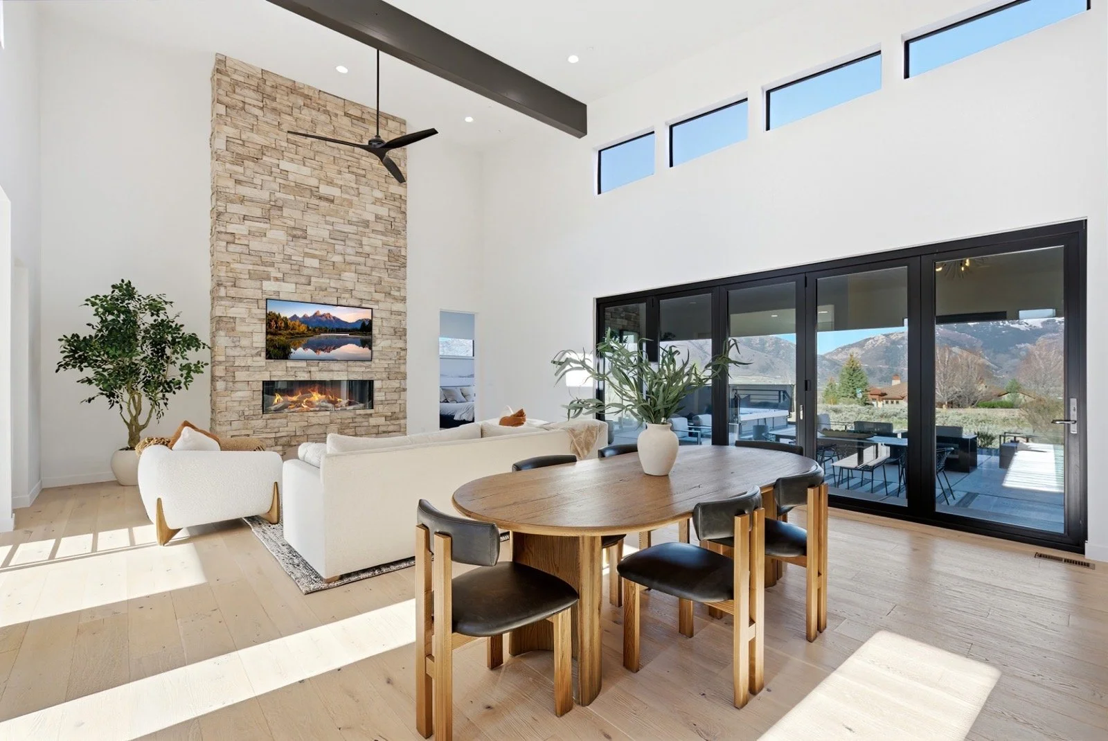 mountain-modern-open-concept-living-dining-stone-fireplace.jpeg