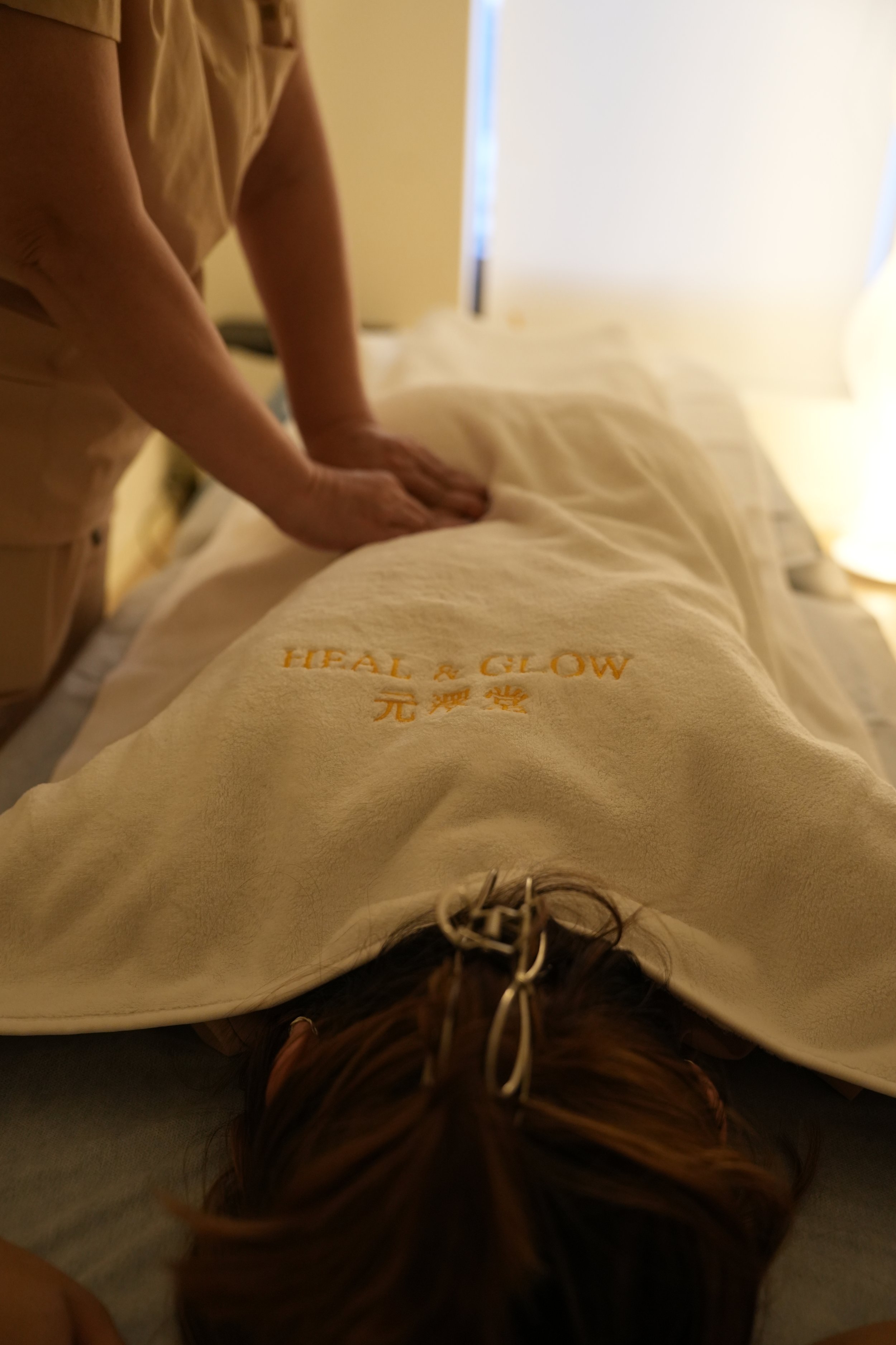 Person receiving a massage on their back in a spa or massage therapy room.