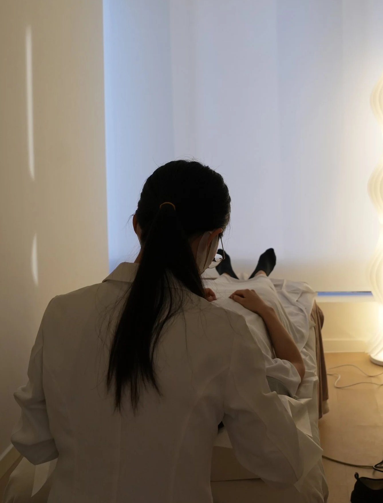 Person receiving acupuncture with thin needles inserted into their back.