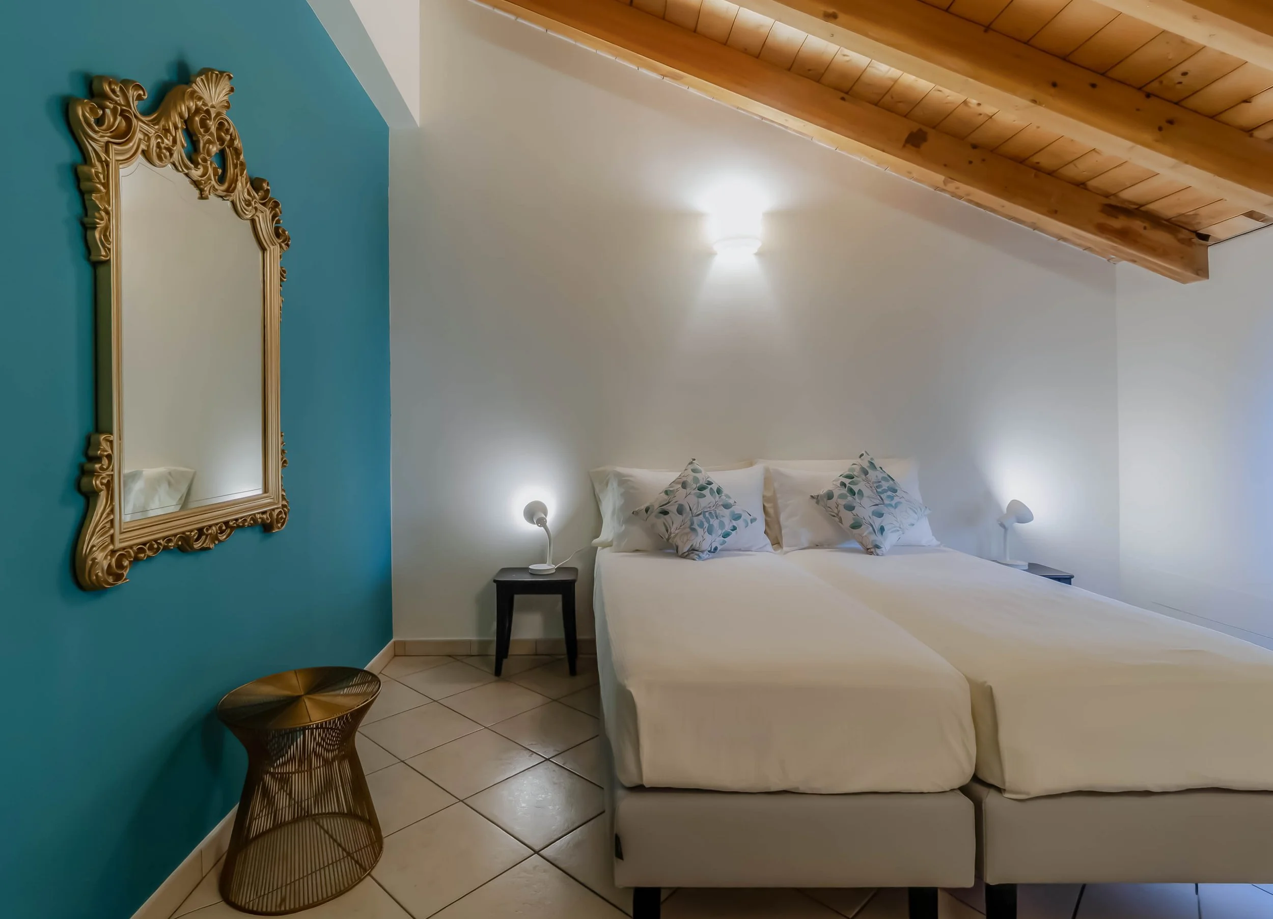 La camera Aura Room – accoglie il riposo come un piccolo rituale fatto di musica, luce soffusa e dettagli che rilassano