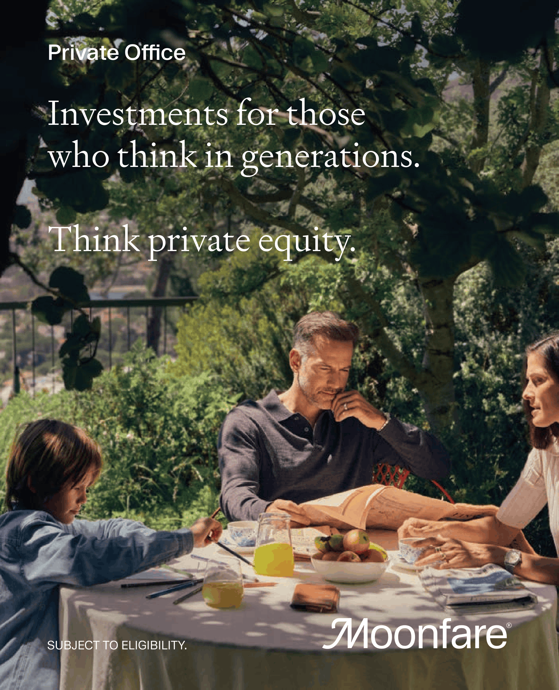 A group of adults and children gathered around a table outdoors under trees, sharing a meal. The table has a white tablecloth, and there are apples, a yellow cup, and various dishes, suggesting a picnic or outdoor dining event.