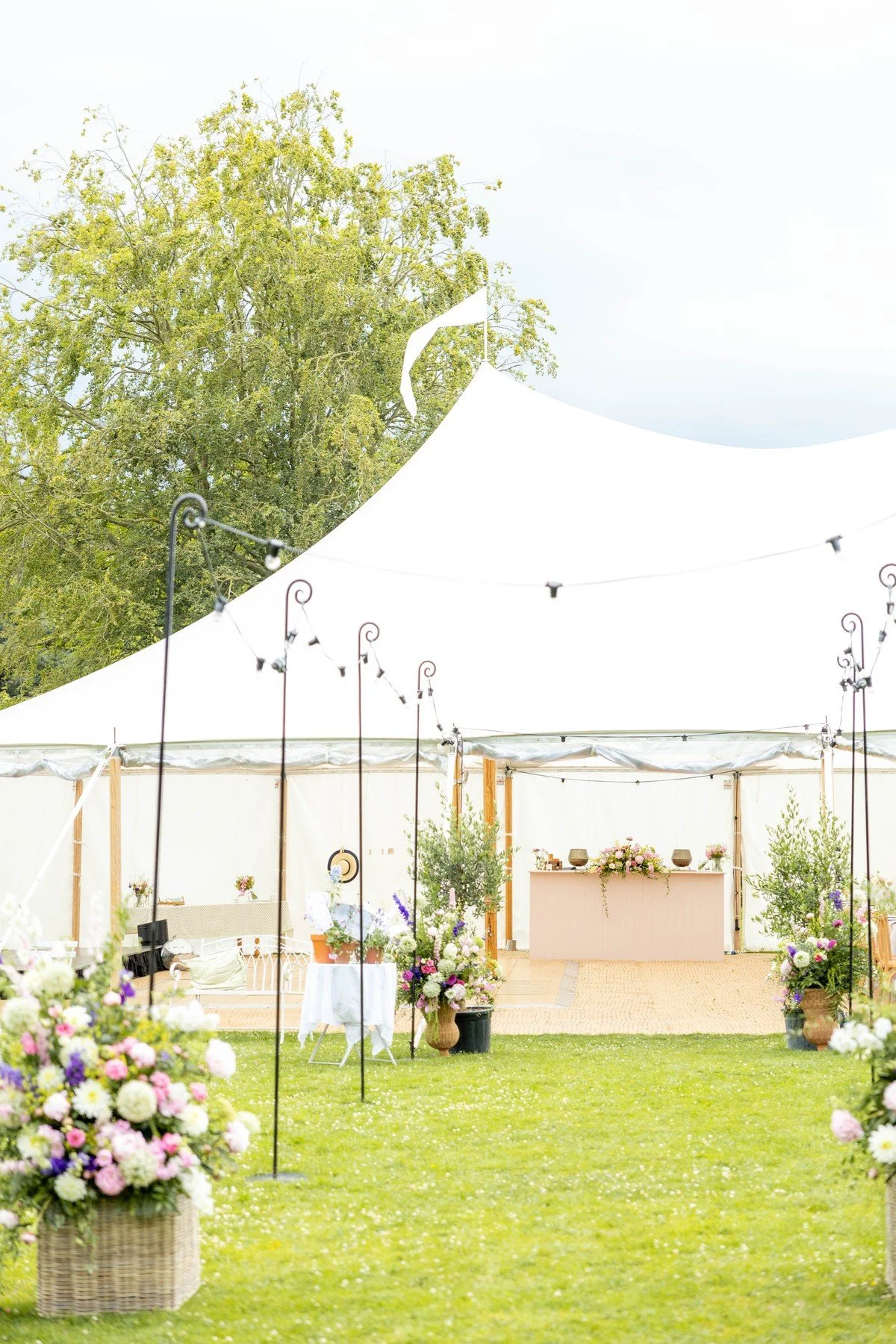 A traditional sailcloth marquee in the meadow adjacent to Meadow House for a wedding