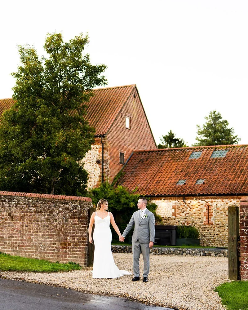 A wedding couple outside the barns on the Barsham Estate