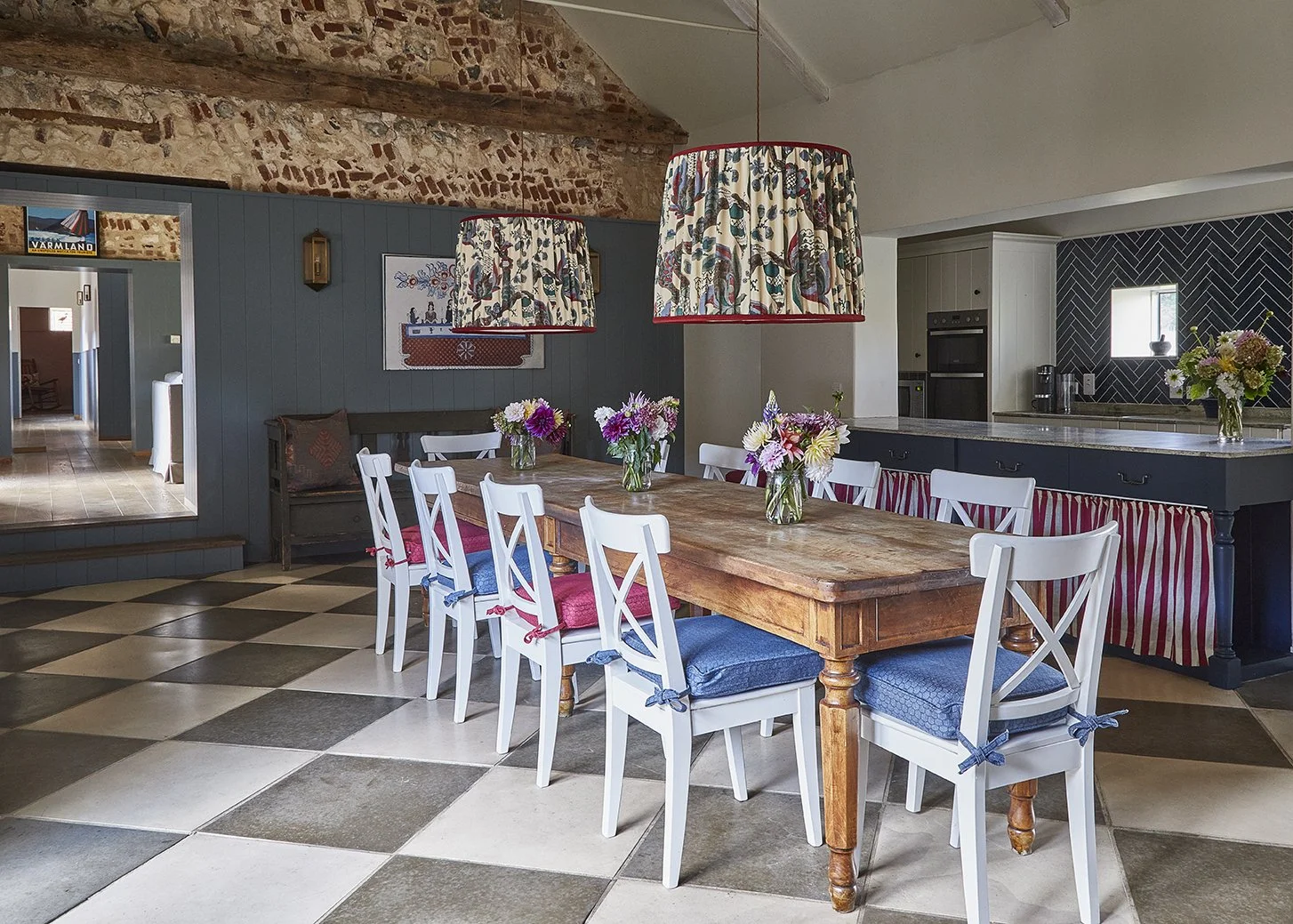The vaulted open plan kitchen and dining room in Greys Court with statement pendant lighting and fabrics by Flora Soames