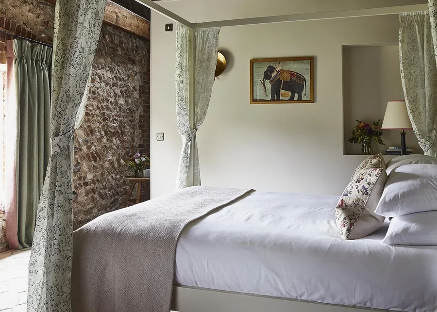 The light-filled master bedroom in High Barsham with four poster bed
