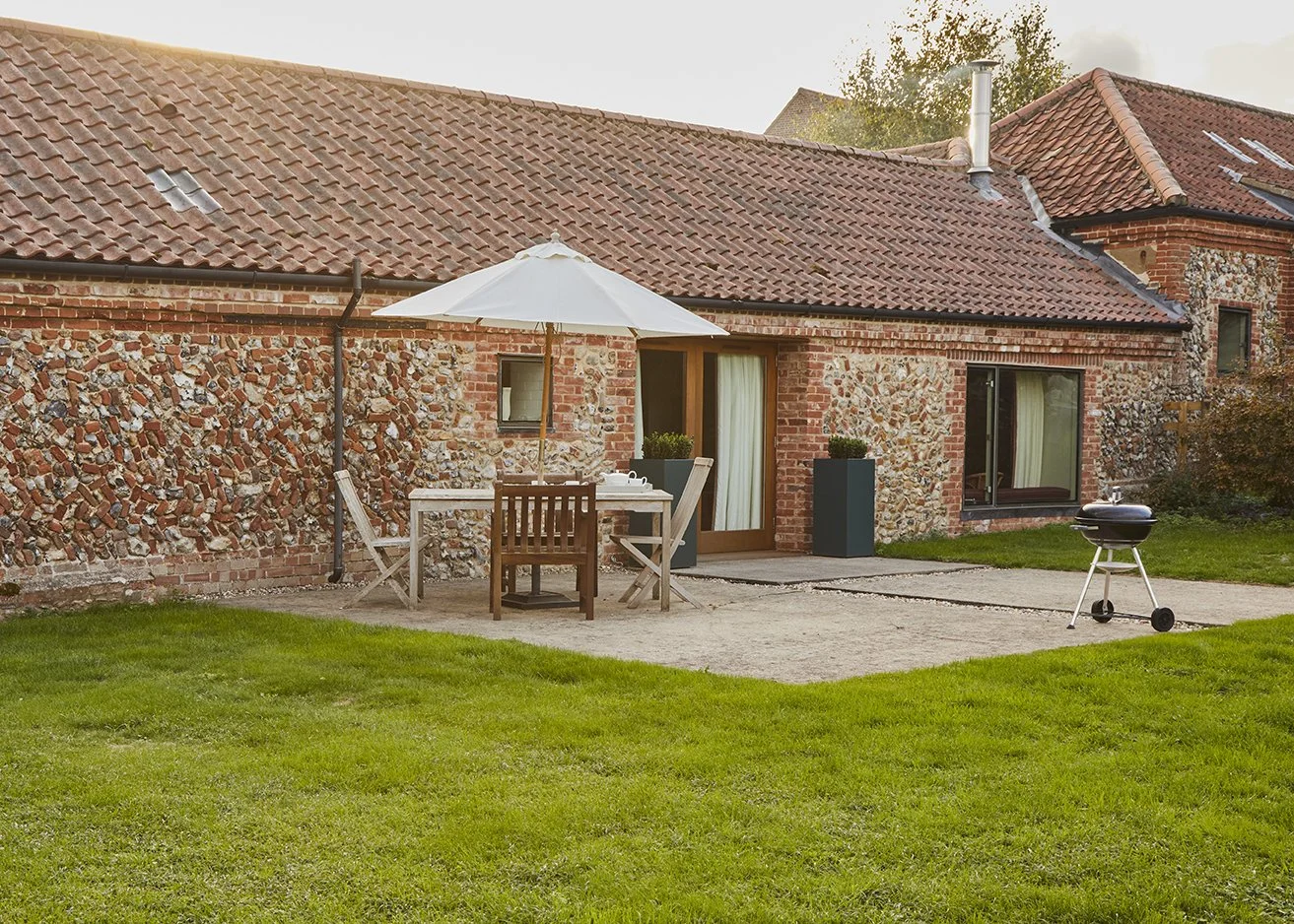 Little Barsham's expansive lawned garden with seating area and BBQ