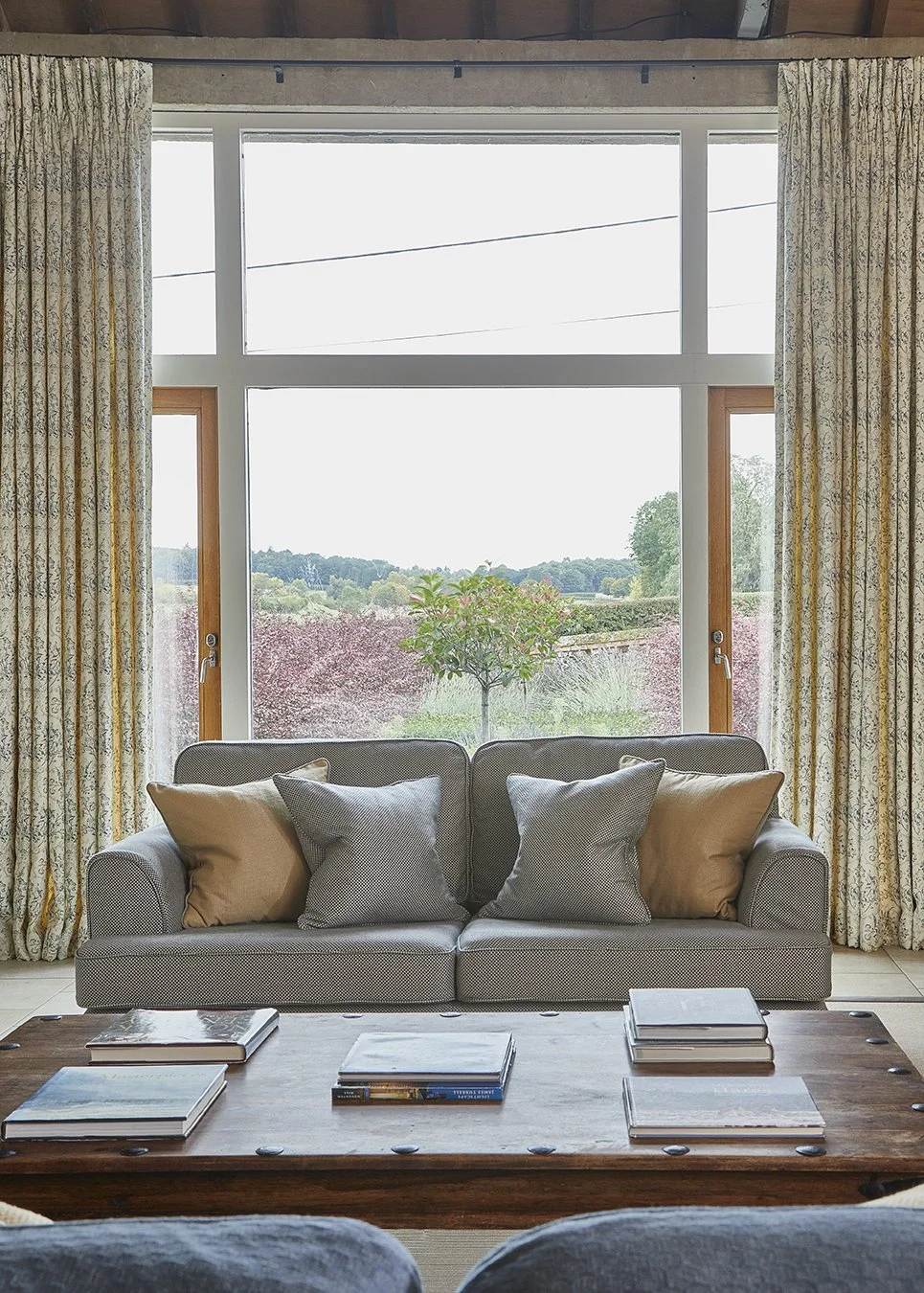 View from the sitting room in Long Meadow through the huge picture window on to the private garden and over the meadows beyond
