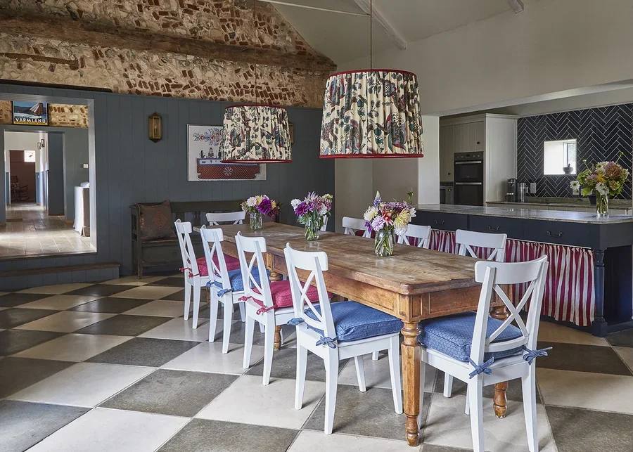 The vaulted open plan kitchen and dining room in Greys Court with statement pendant lighting and fabrics by Flora Soames