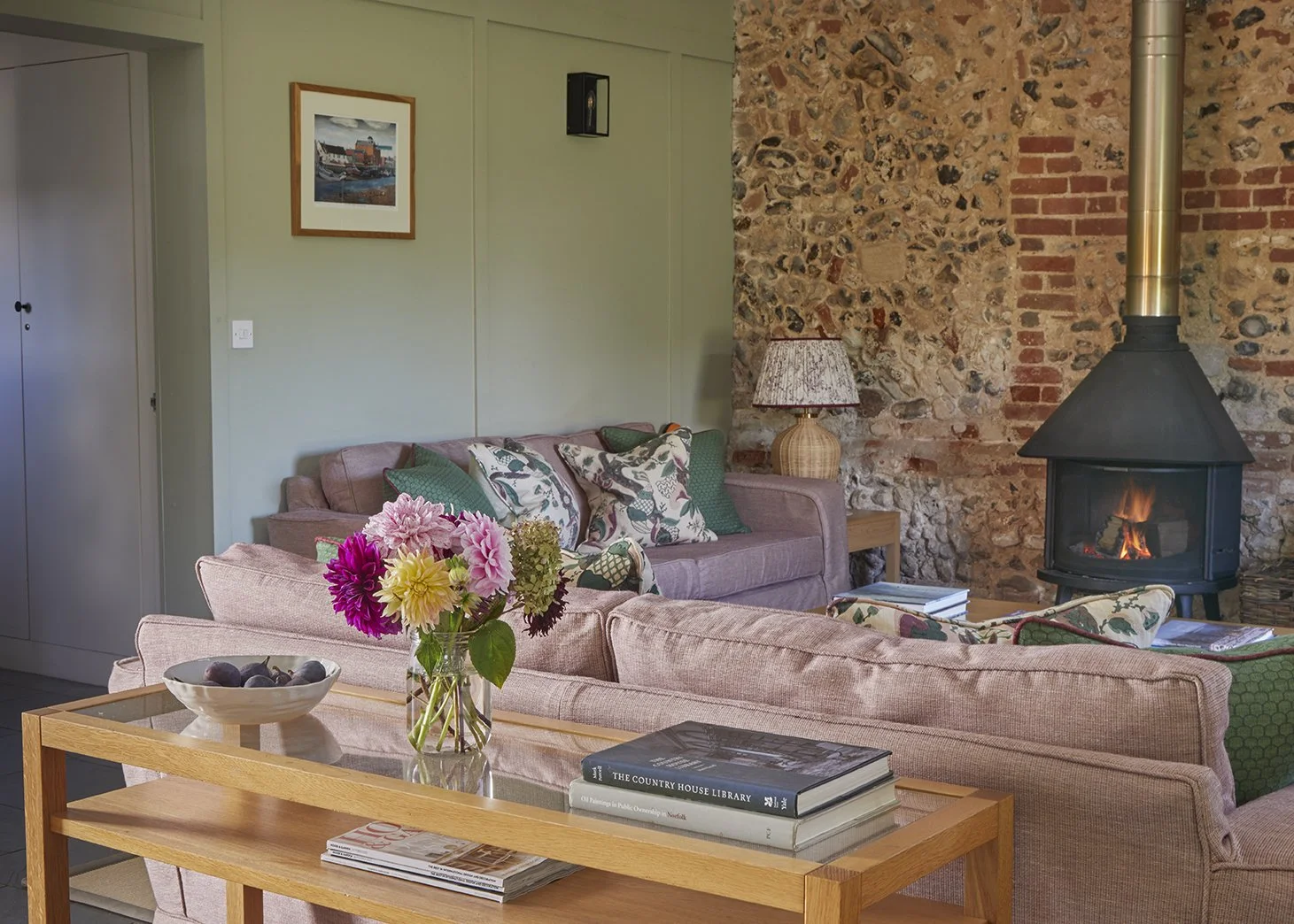 The vaulted open-plan living and dining area in Little Barsham with roaring wood burner