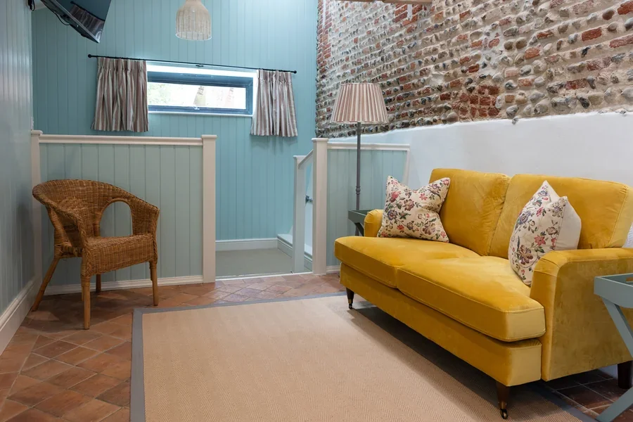The open-plan living area with exposed brick and flint wall in Little Sandford