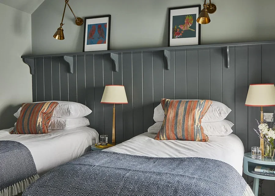 The stylish twin bedroom in The Loose Box with tongue and groove cladding and rich colours