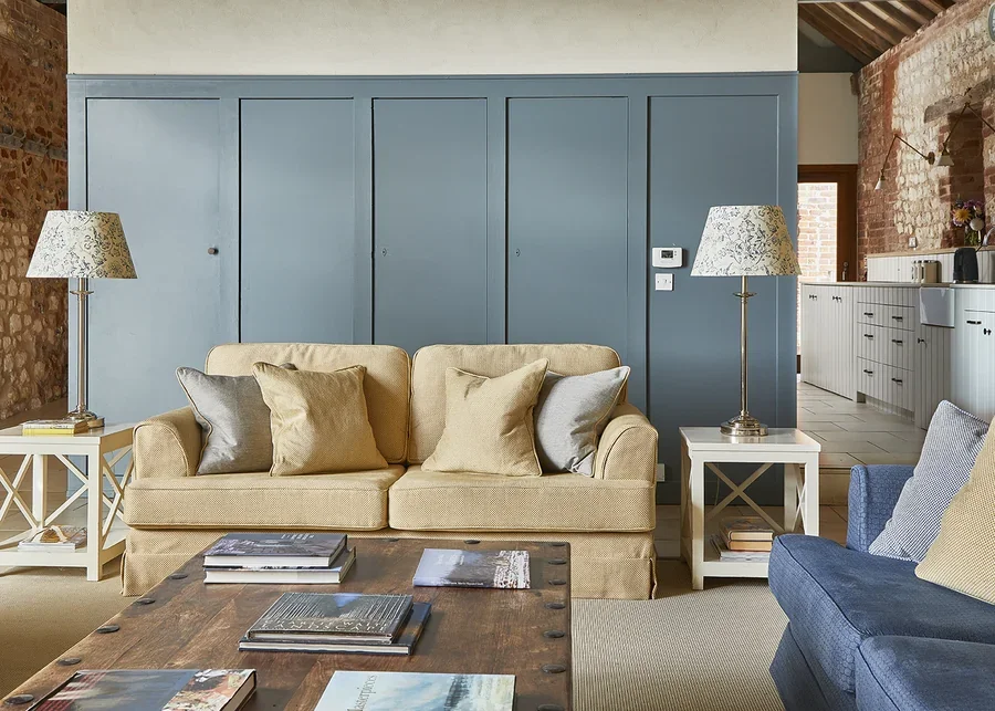 The elegant, light-filled sitting room in Long Meadow with open-plan kitchen in the background