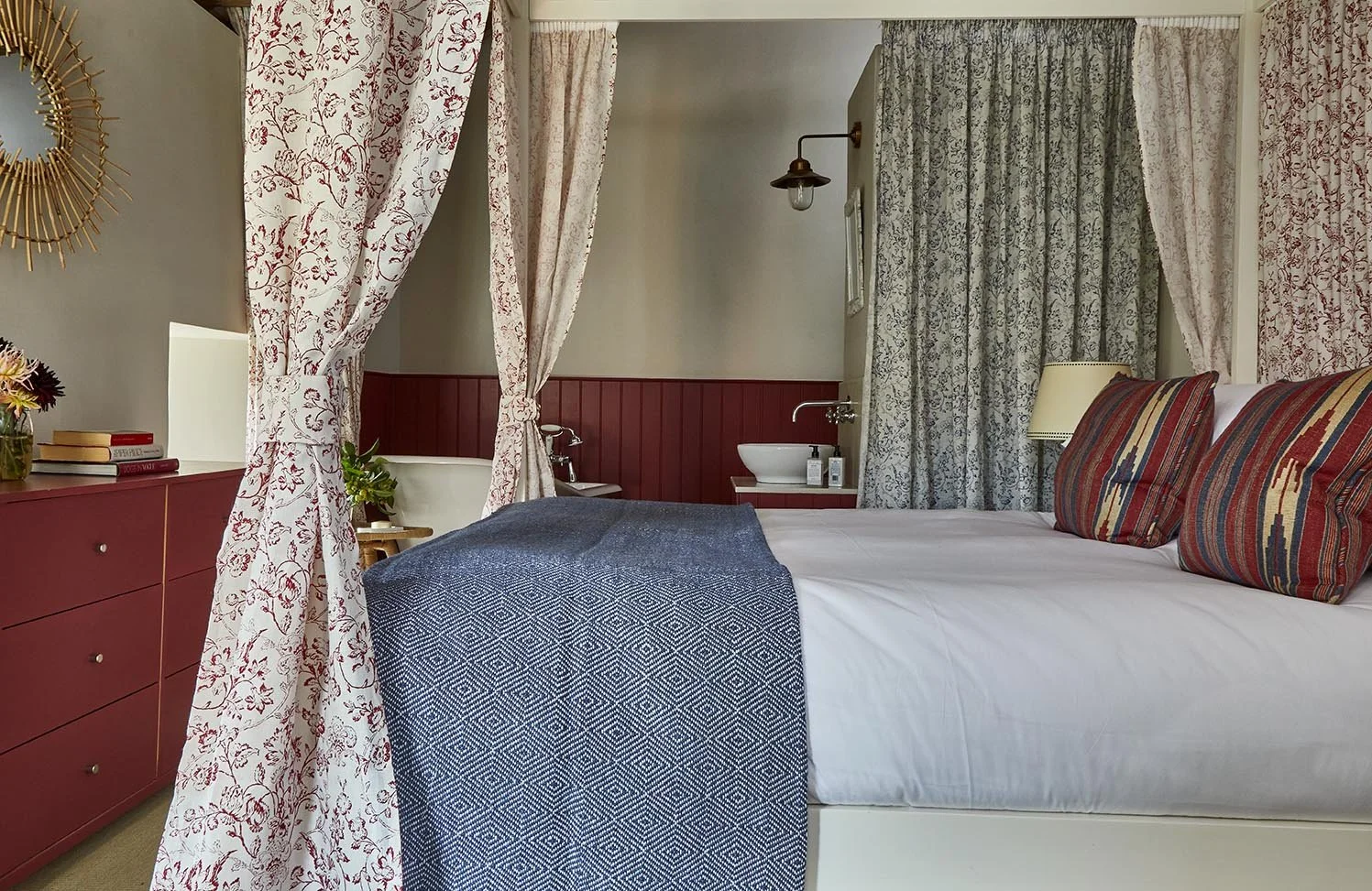 Great East's main bedroom with a four poster bed and roll top bath