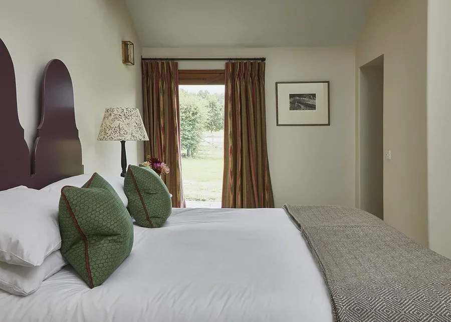 An airy and spacious double bedroom with feature headboard and a door out to the garden