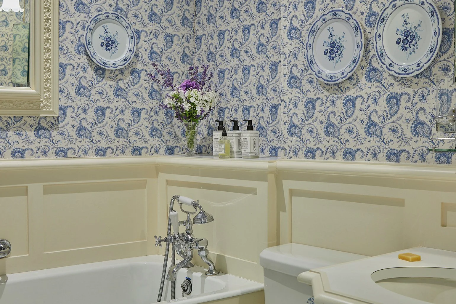 A blue-wallpapered bathroom in Meadow House