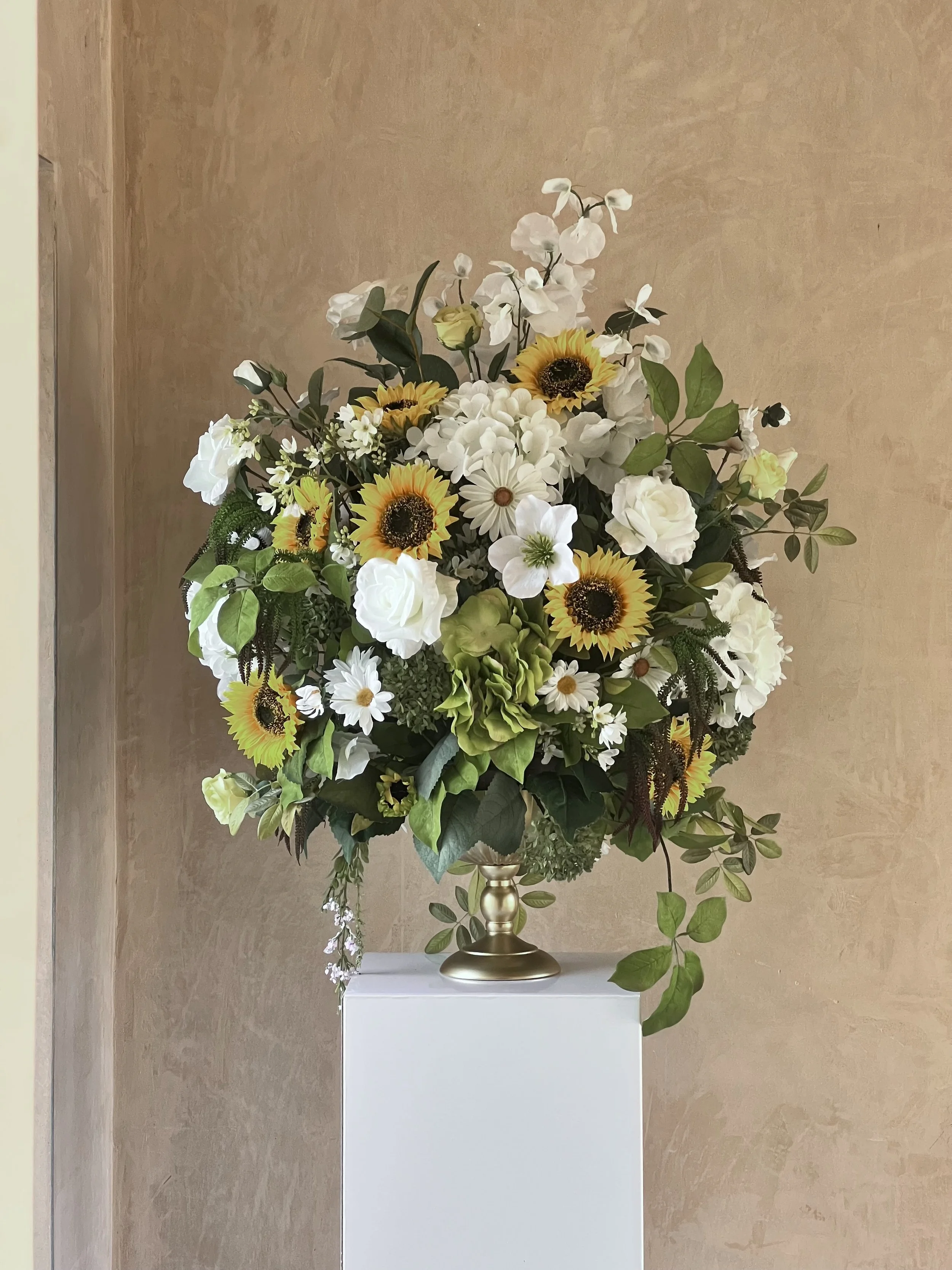 While white large urn customised with sunflowers and yellow roses