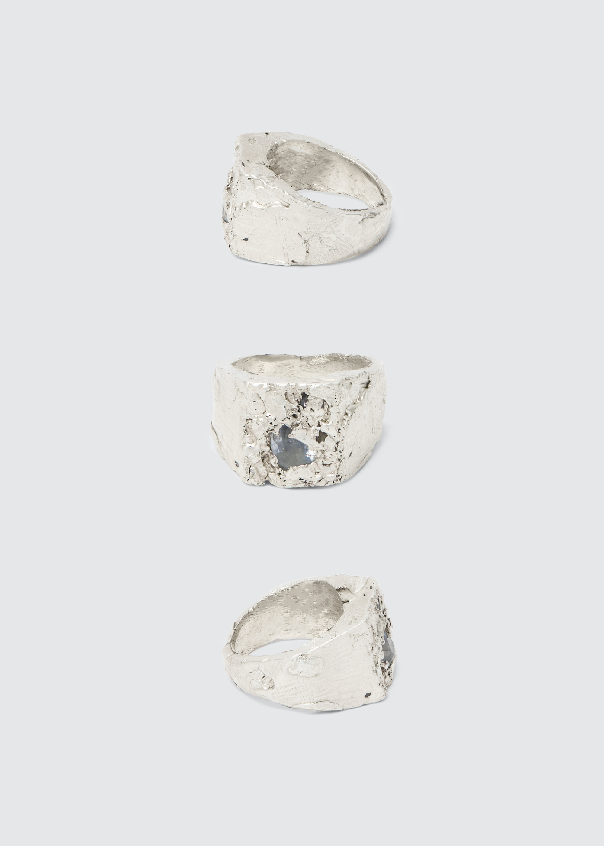 A silver ring with an abstract, rugged design, photographed against a plain white background.