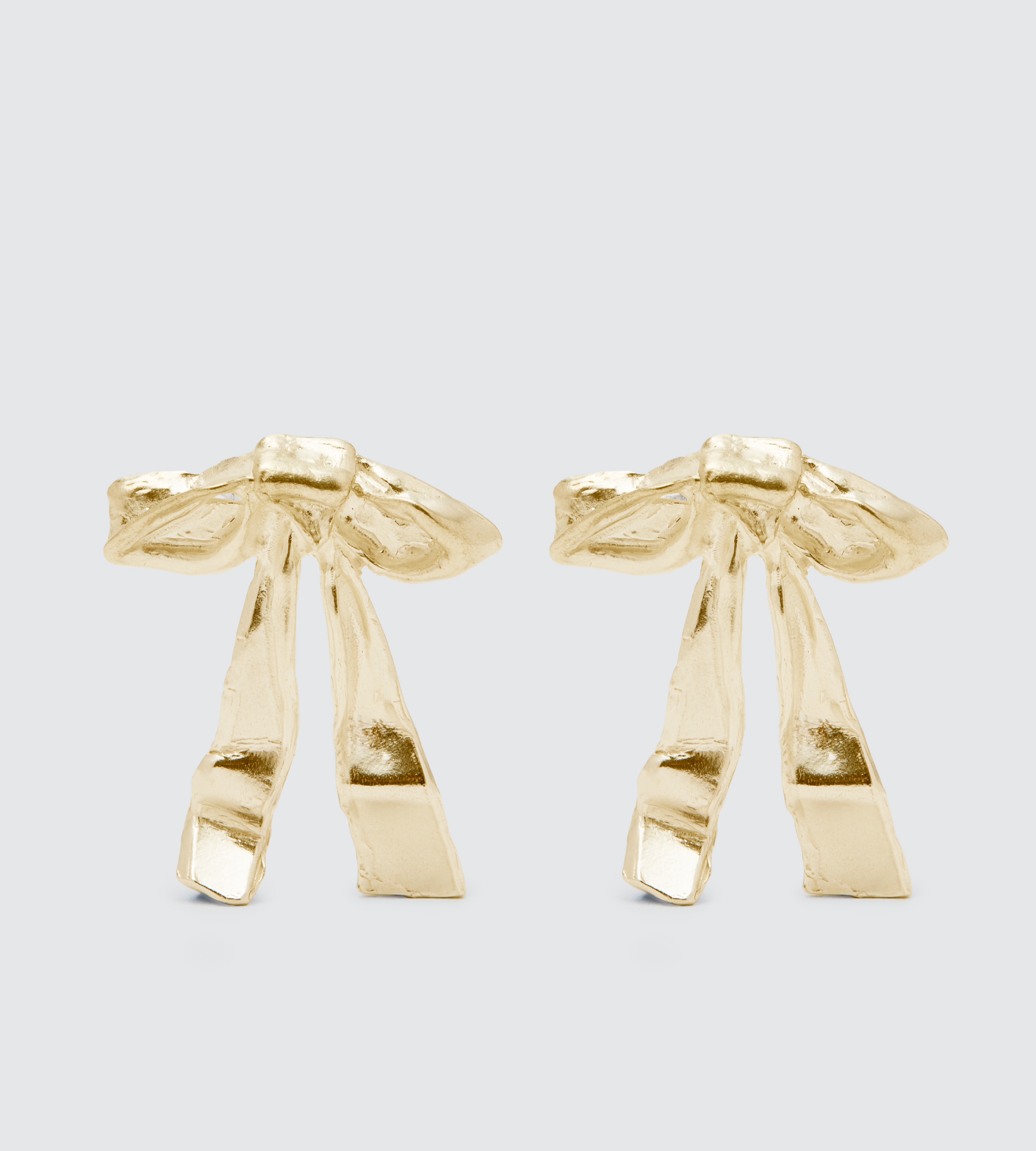 Two gold-colored nail clippers on a light gray background.