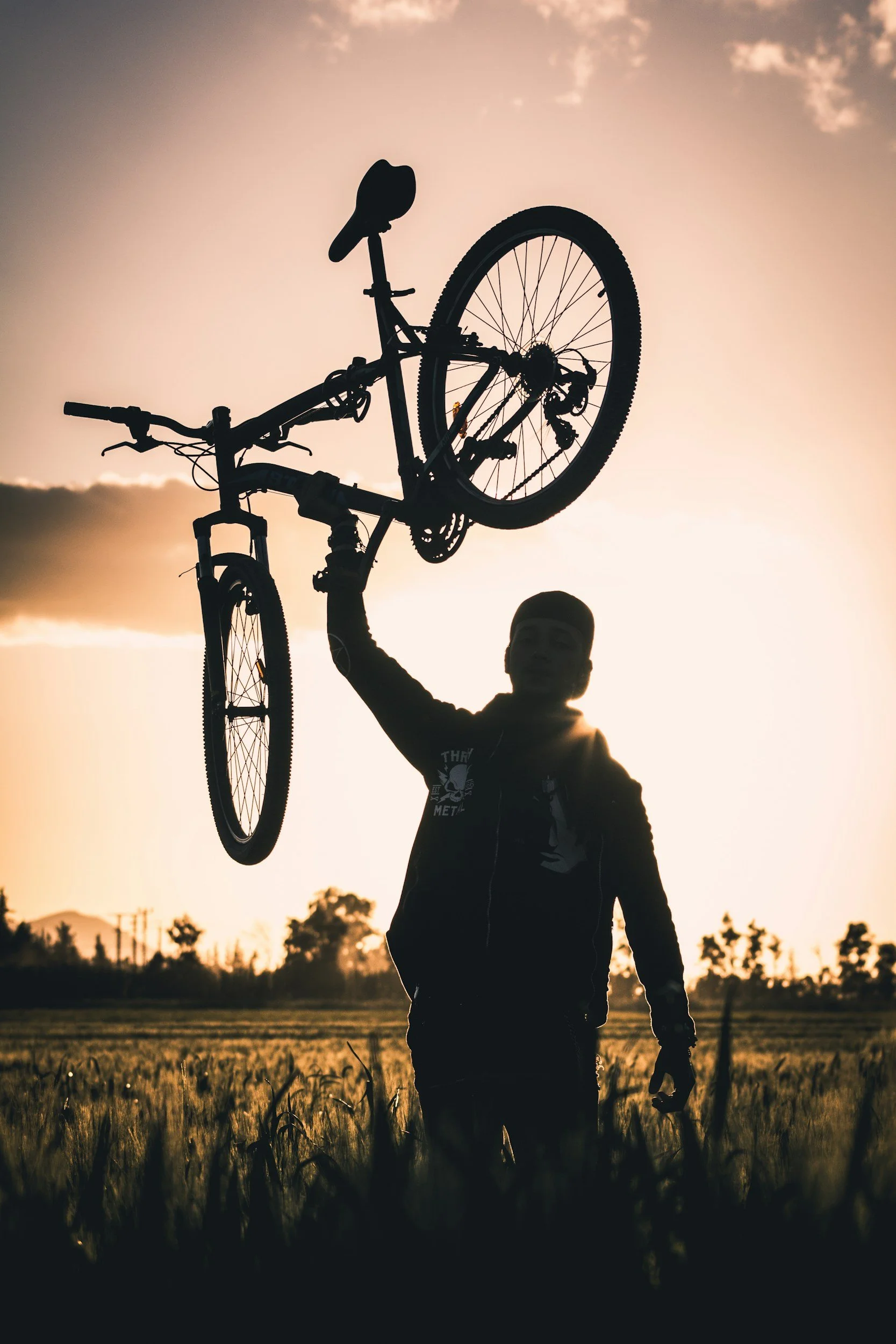 Man Exultantly holding a bicycle aloft