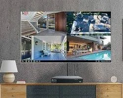 Bir oturma odasında duvara asılmış büyük ekran televizyon ve onun altında bir medya oynatıcı. Televizyonun üzerinde ve çevresinde çeşitli iç mekanı gösteren dört küçük ekran var. Oda ortasında küçük bir sehpa ve yanlarda iki adet masa lambası bulunuyor.