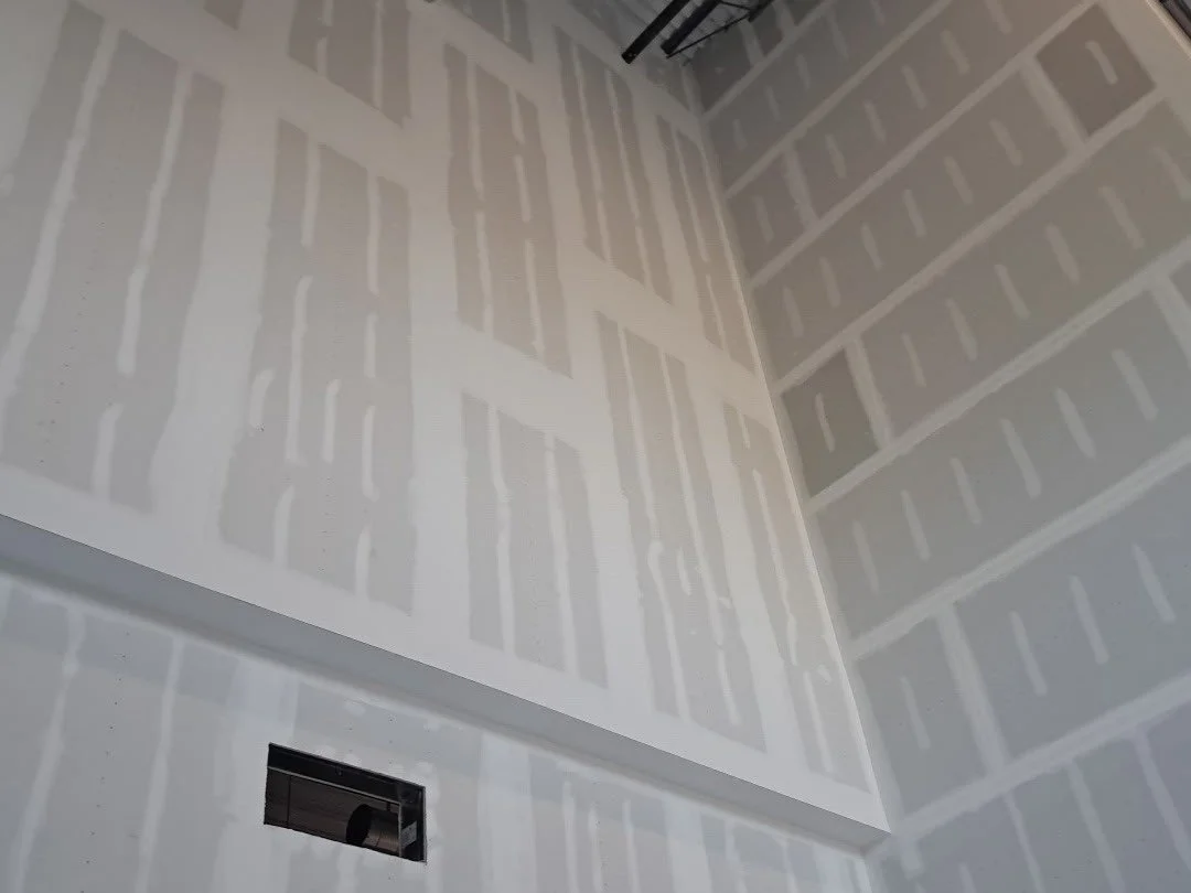 	
Interior of a large industrial warehouse under construction with demising wall finish taped.