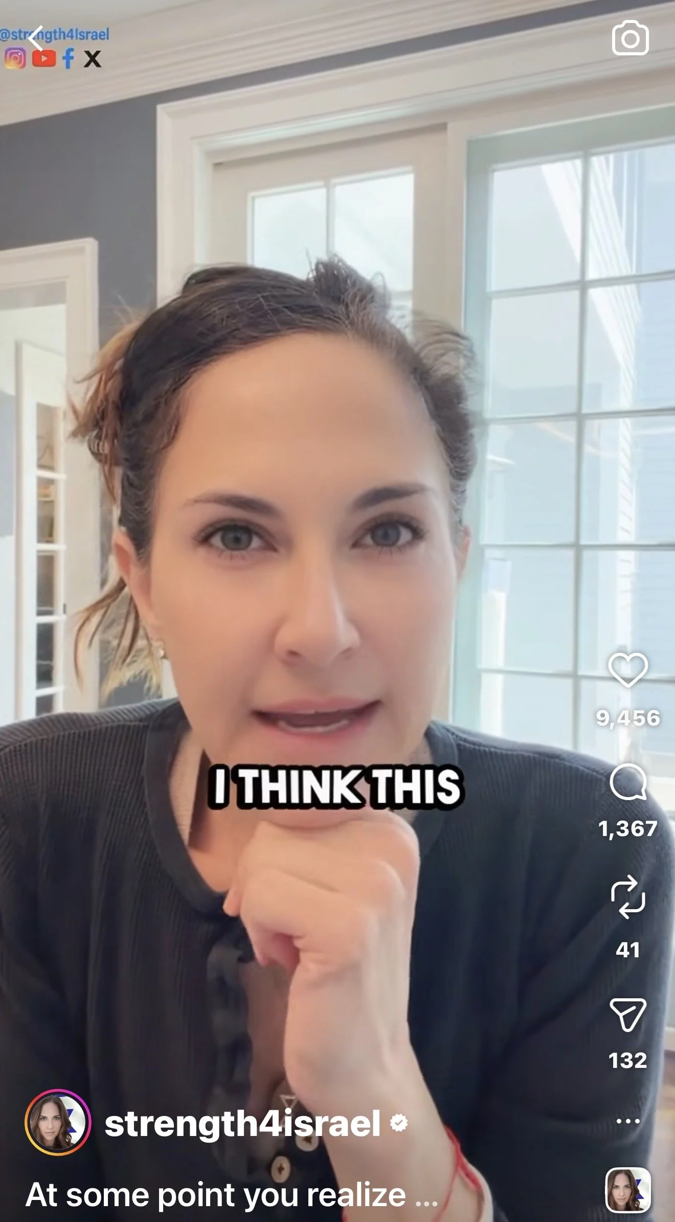 A woman with short brown hair and gray eyes pointing at the camera. She is indoors with a window behind her. The caption says "I THINK THIS".