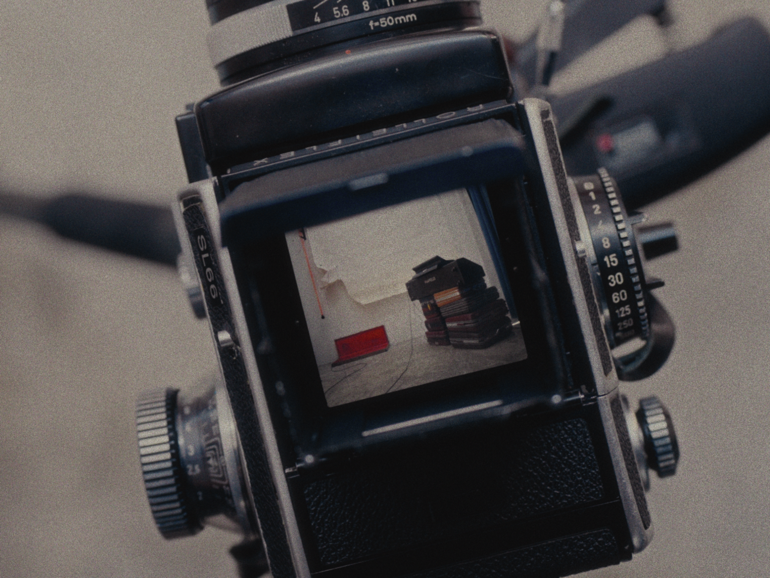 A vintage film camera capturing an image of a bookshelf filled with books.