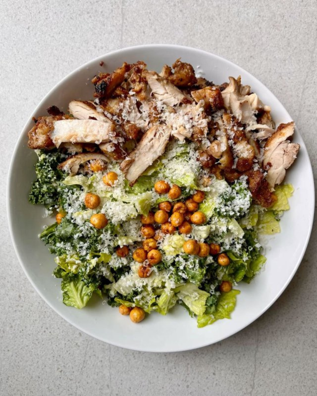 Salad with grilled chicken, chickpeas, shredded cheese, and lettuce.