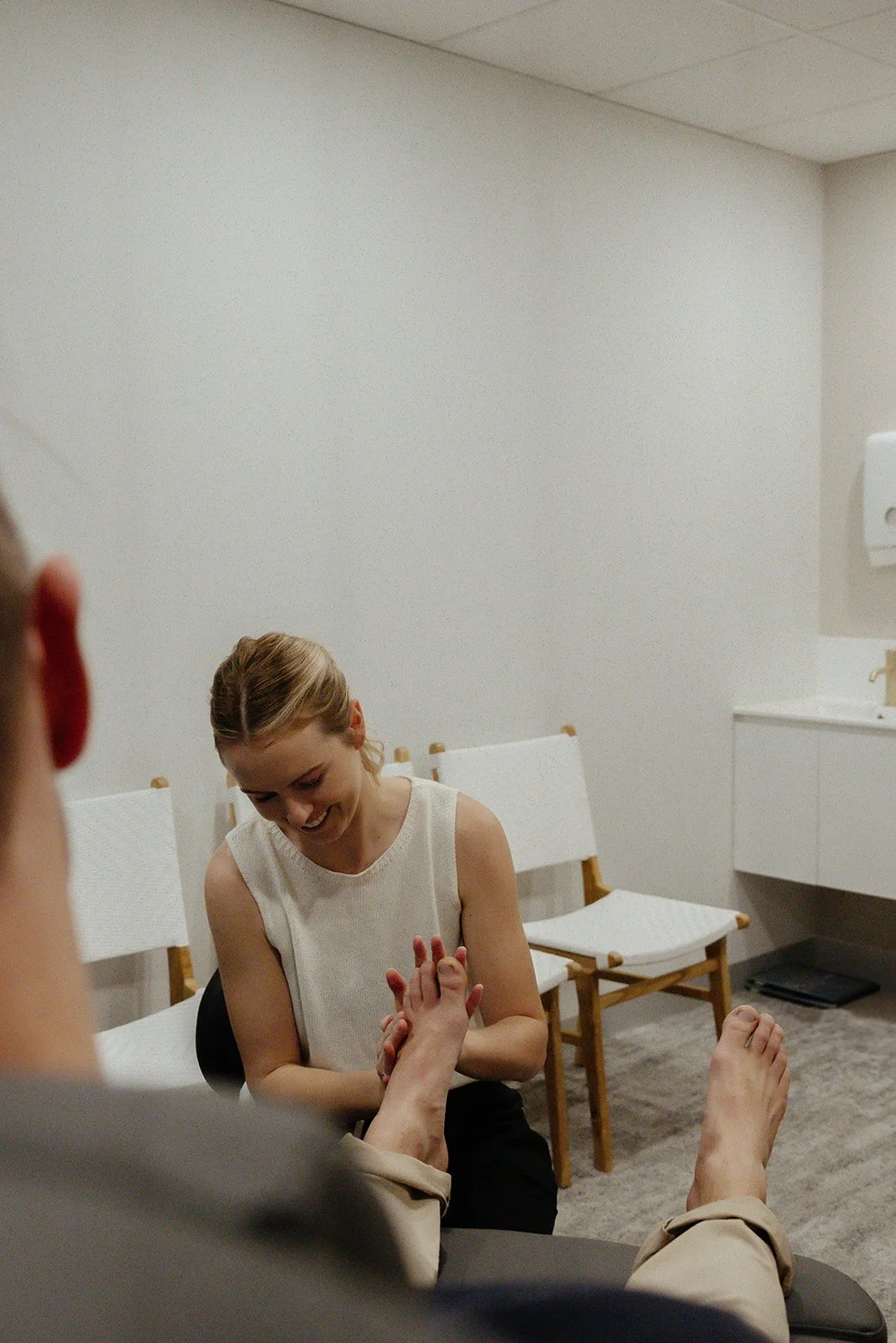Podiatrist, Caitlen Baldock assessing a patients foot in Peregian Foot Clinic.