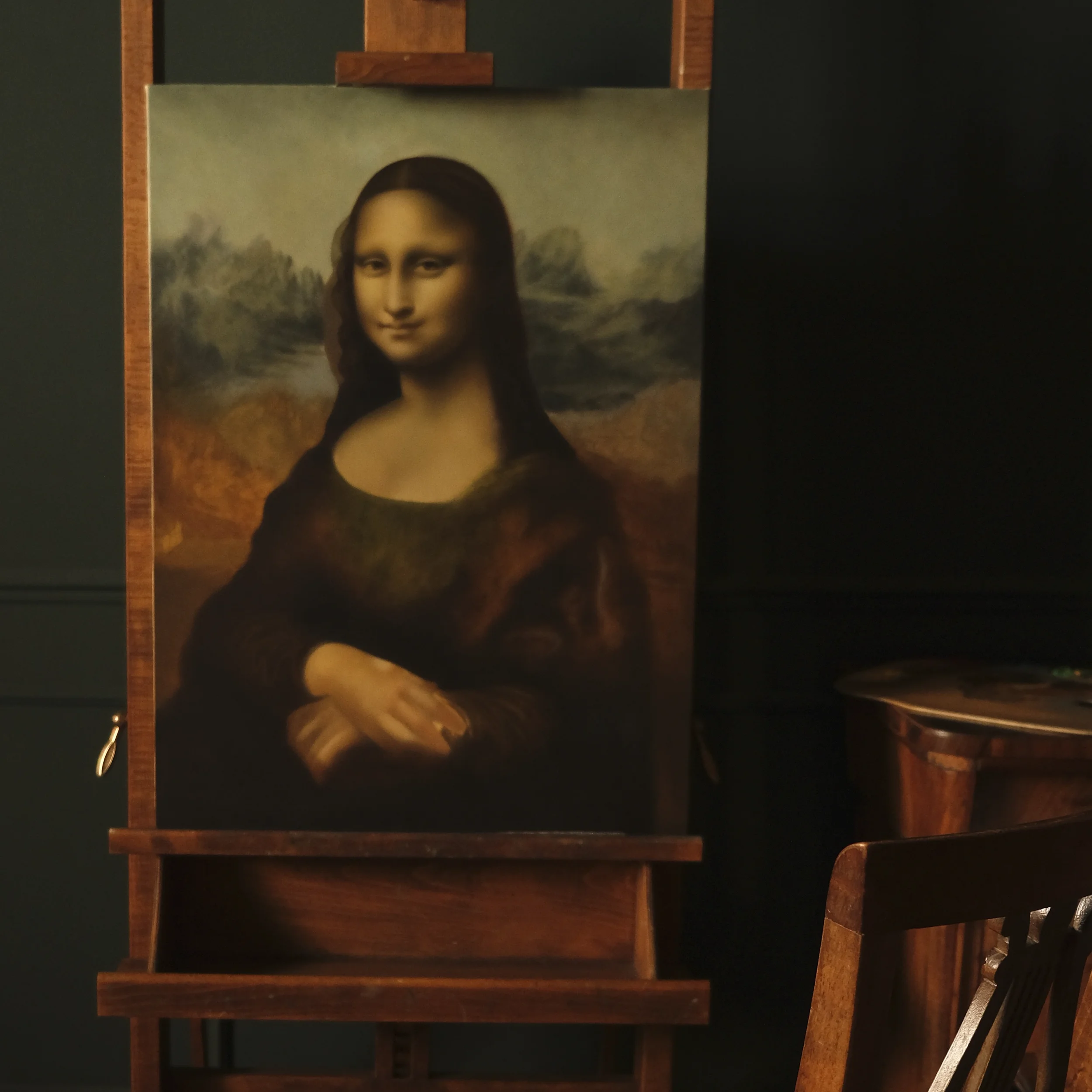Reproduction of Leonardo da Vinci’s Mona Lisa, painted by Anna Sumislawska and displayed on a wooden easel in a room with dark green walls. The painting was created with oil paints on canvas using cruelty-free, vegan brushes.