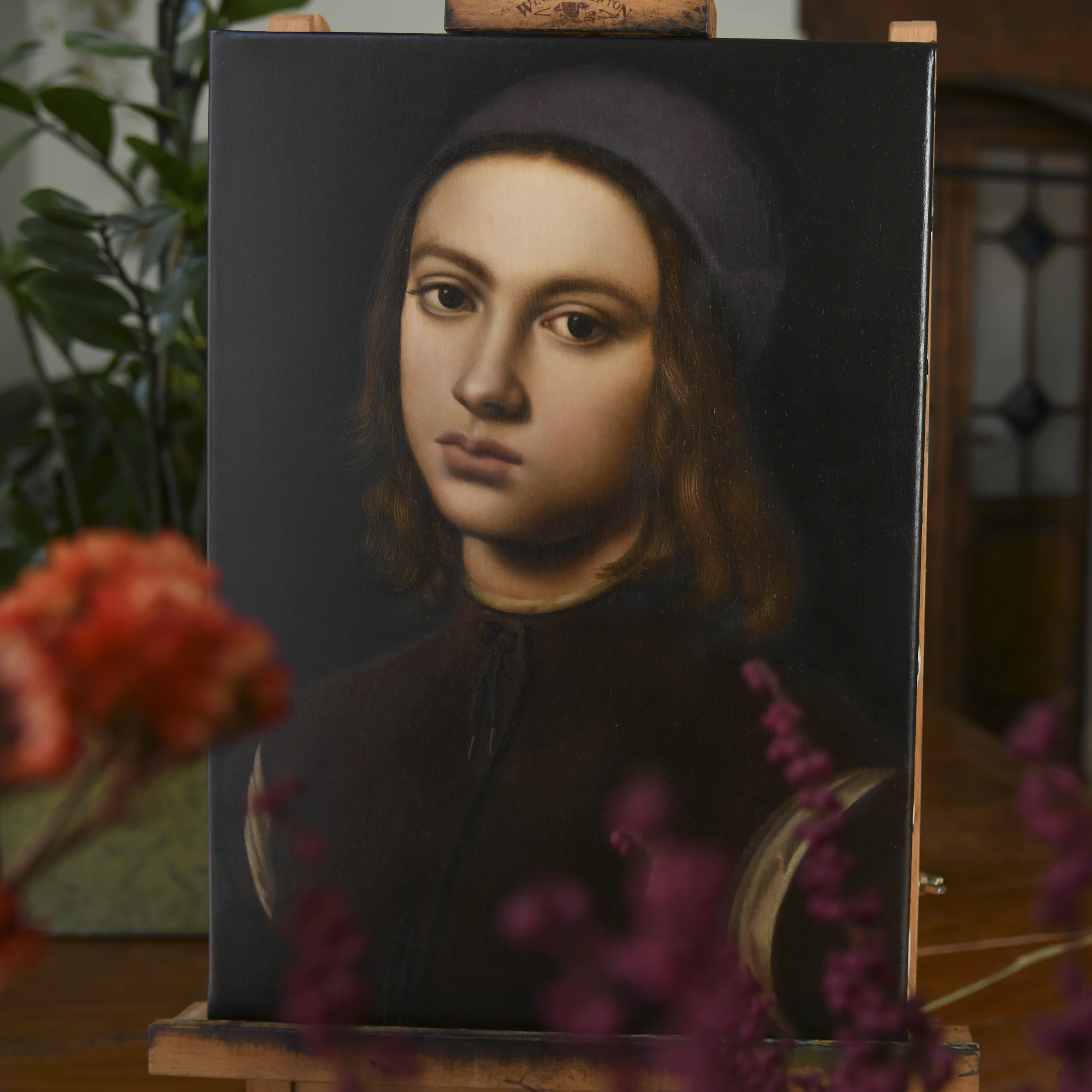 Oil painting copy by Anna Sumislawska of a portrait of a young boy by Perugino, displayed on a small wooden easel, inspired by the original work housed at the Palazzo Pitti in Florence.
