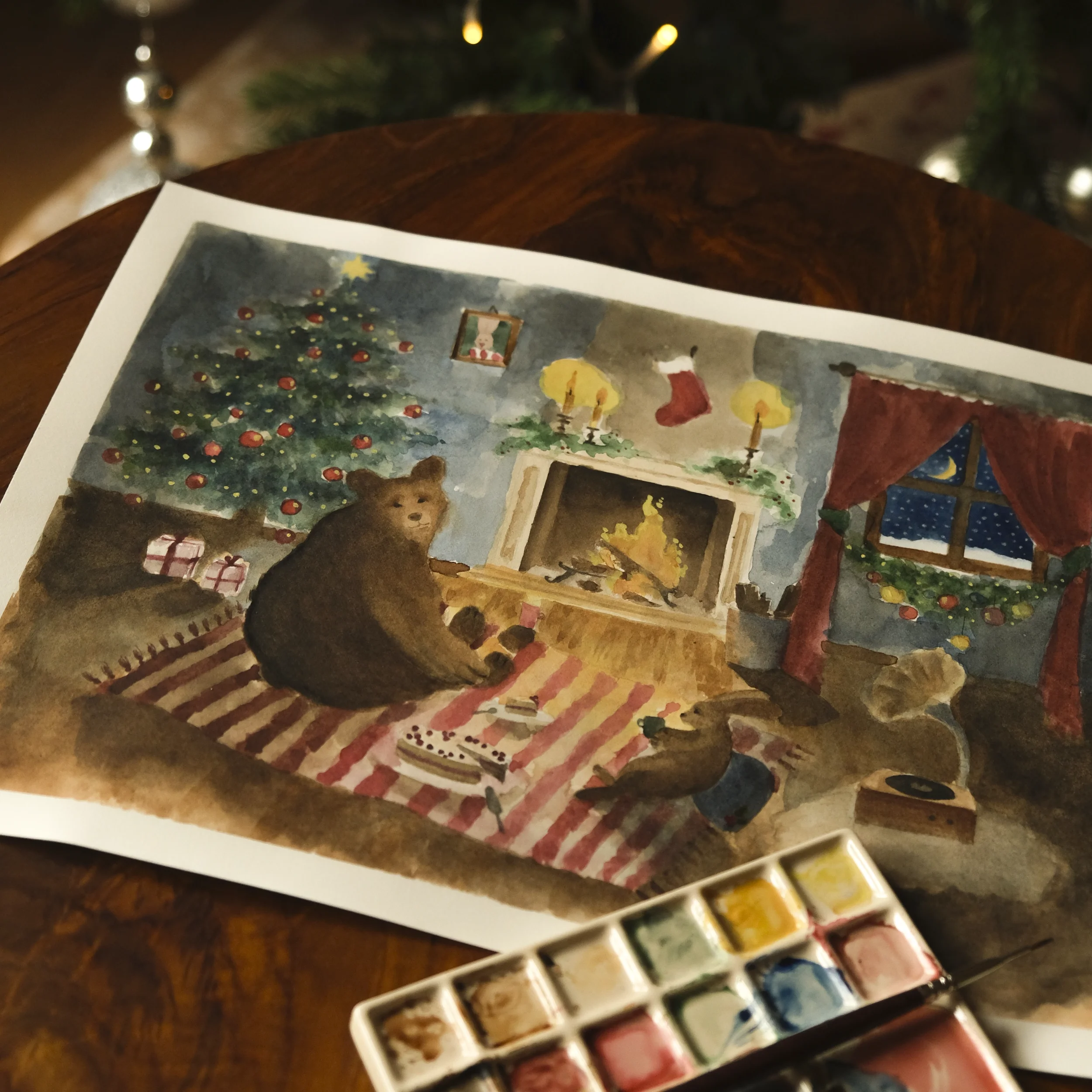 Watercolour painting of a Christmas scene featuring animal characters, including Torsolo the bear and Kornelius the rabbit, enjoying cake and tea in front of a fireplace, with a Christmas tree in the corner.