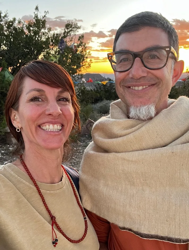 Elisa and Sam from Open Hand Somatic Ecology Project smiling together outdoors at sunset.