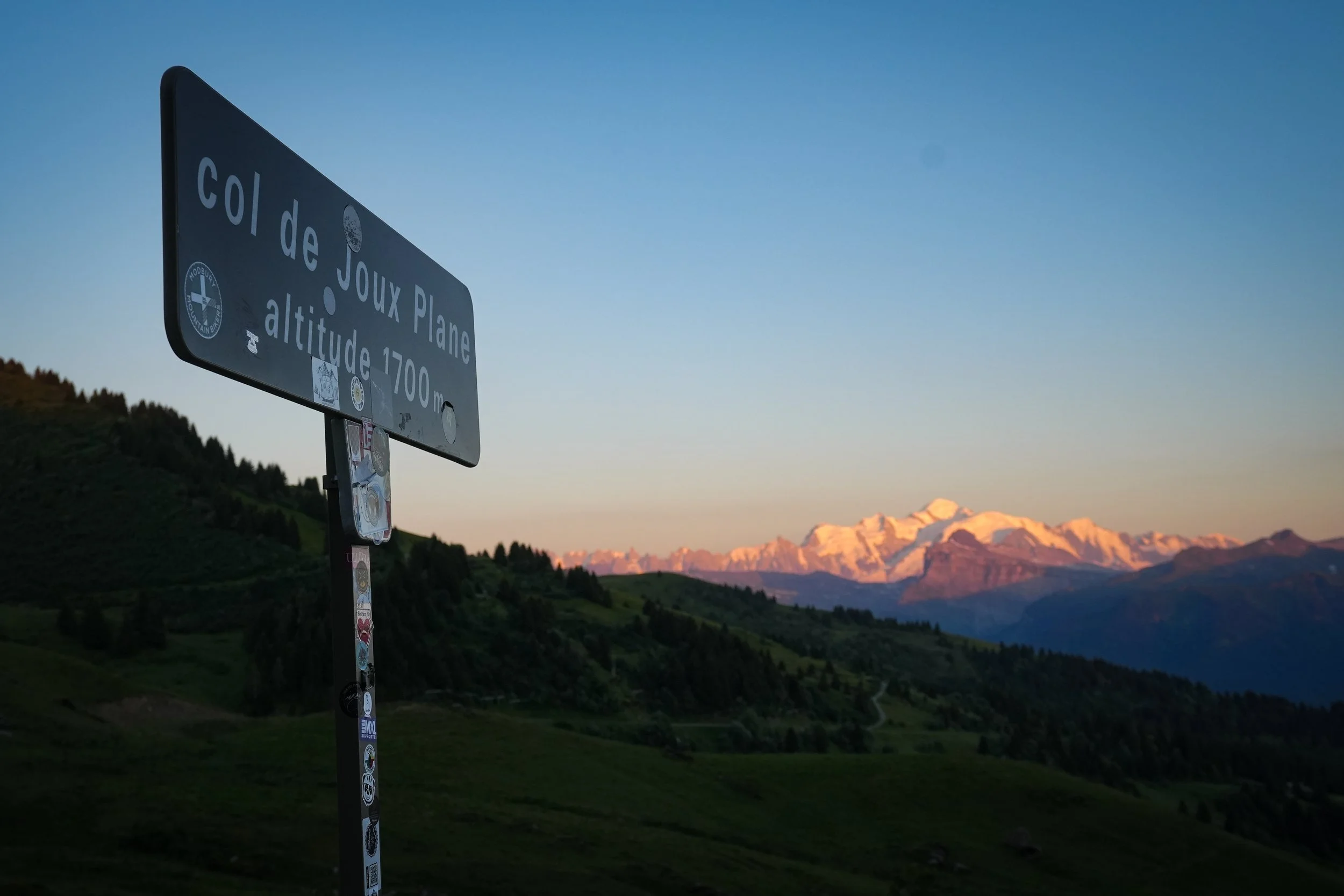 Sign indicating the Cop de Joux Plane at an altitude of 1700 meters with a scenic mountain landscape in the background.