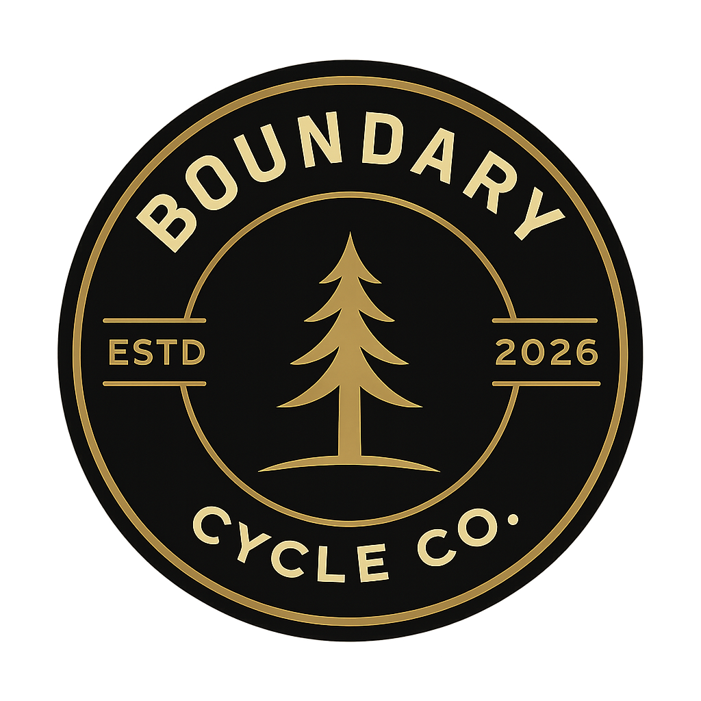 A circular logo for Boundary Cycle Co. featuring a pine tree in the center. The logo has a black background with gold text and design elements, including the words 'BOUNDARY' at the top, 'CYCLE CO.' at the bottom, and 'ESTD 2026' on each side of the pine tree.
