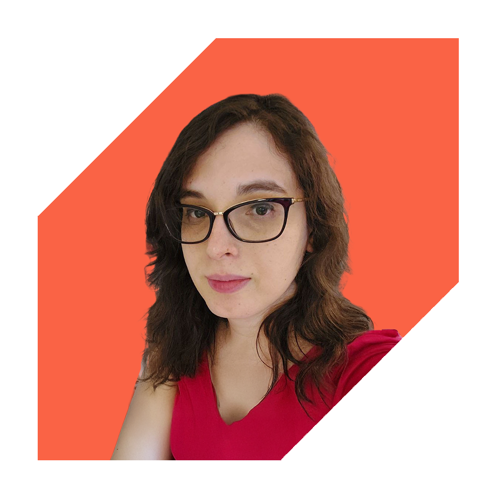 A woman with wavy brown hair wearing glasses and a red top.