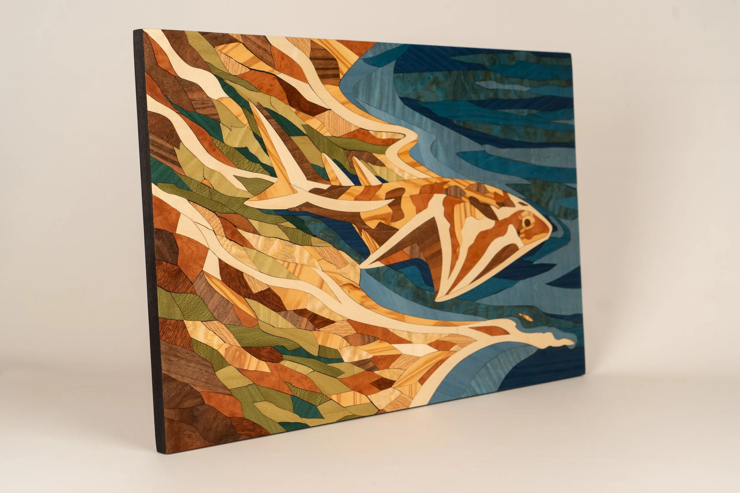 Marqueterie Baie des anges de côté. Essences : Charme, chêne, frêne, frêne pommelé, loupe de madrona, noyer ramageux, noyer, olivier, platane maillé, sipo, sycomore ondé, sycomore, tulipier