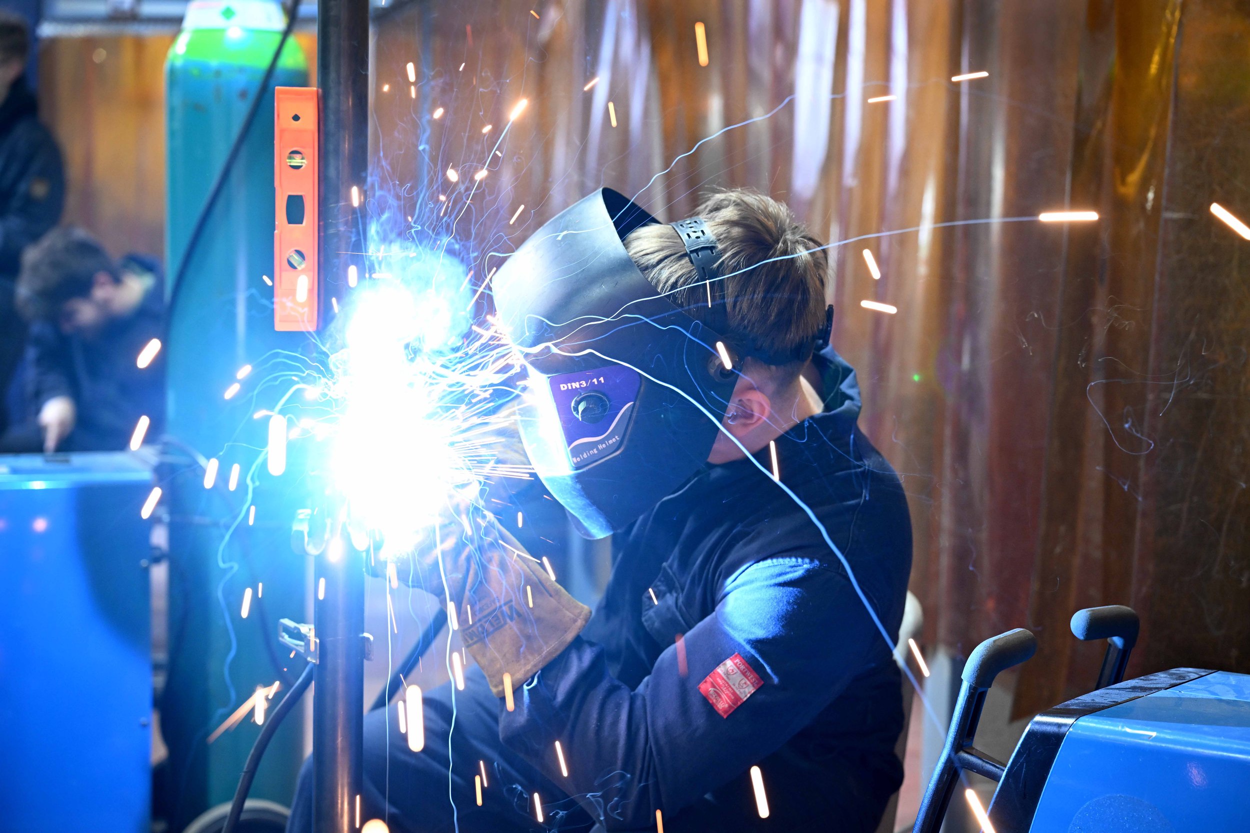 Student welding and fabricating in a workshop.