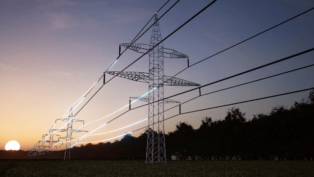 High-voltage power lines and pylons at sunset or sunrise with a clear sky and some trees in the background.