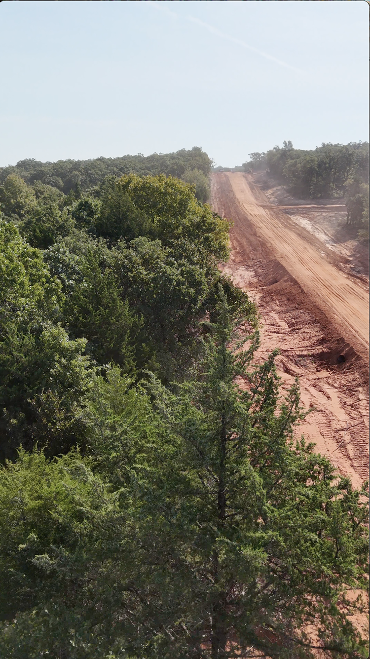Oklahoma property before firebreak creation — dense brush and cedar near structure