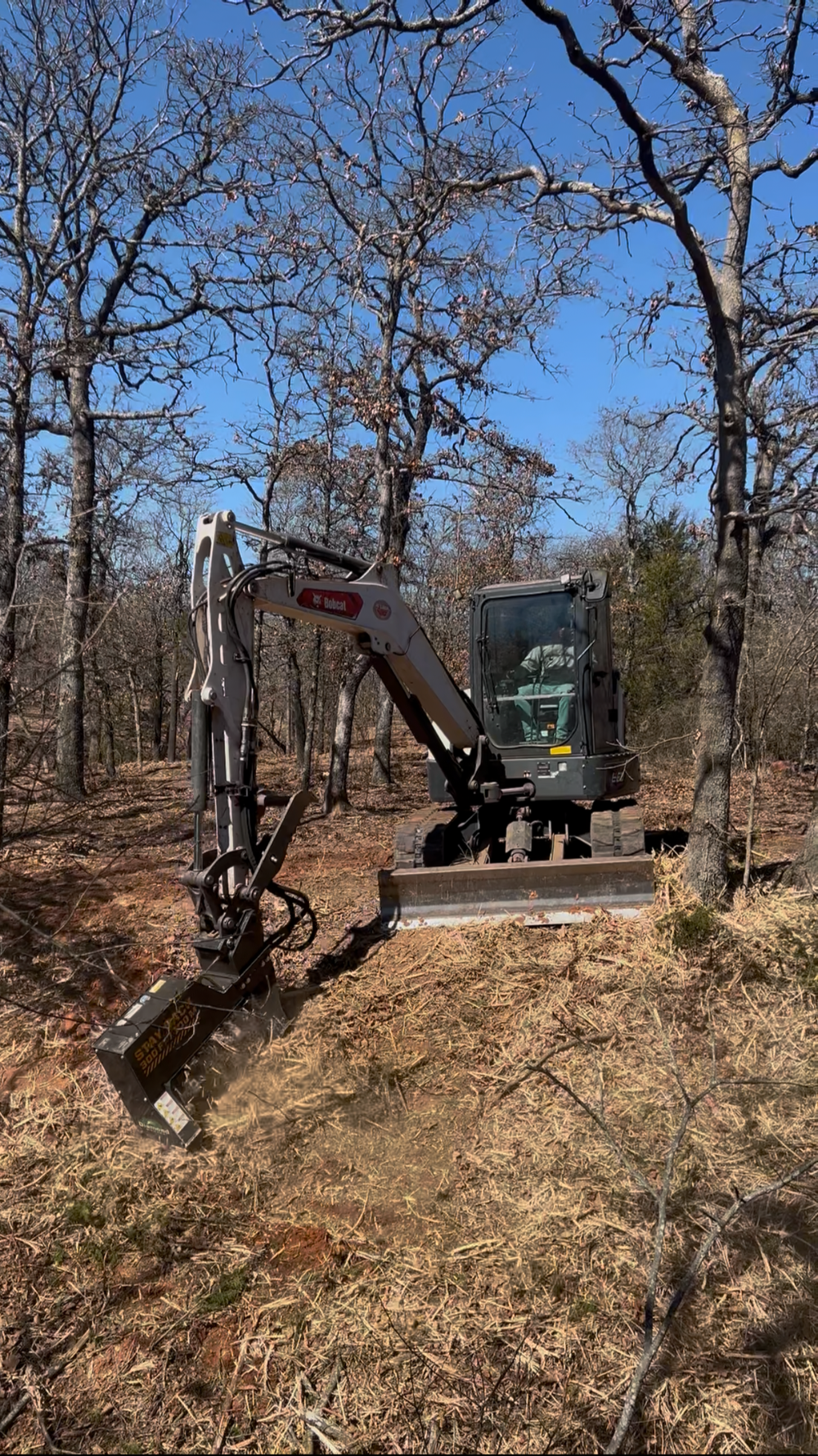 Excavator clearing cedar trees on Oklahoma property