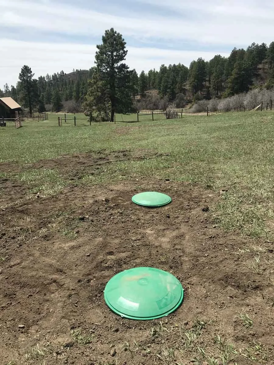 green septic risers in the dirt
