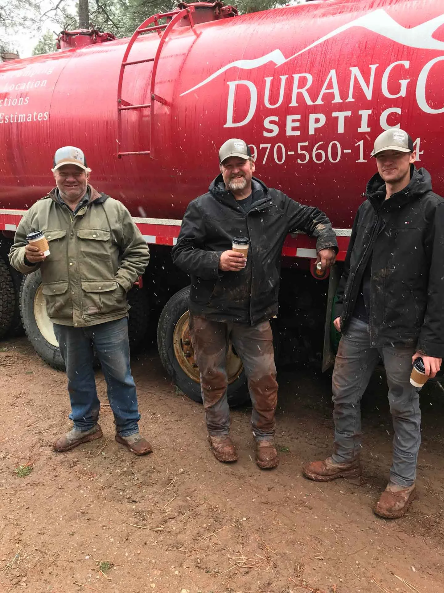 three staff members standing next to a red septic truck ready to perform Cortez Septic Services