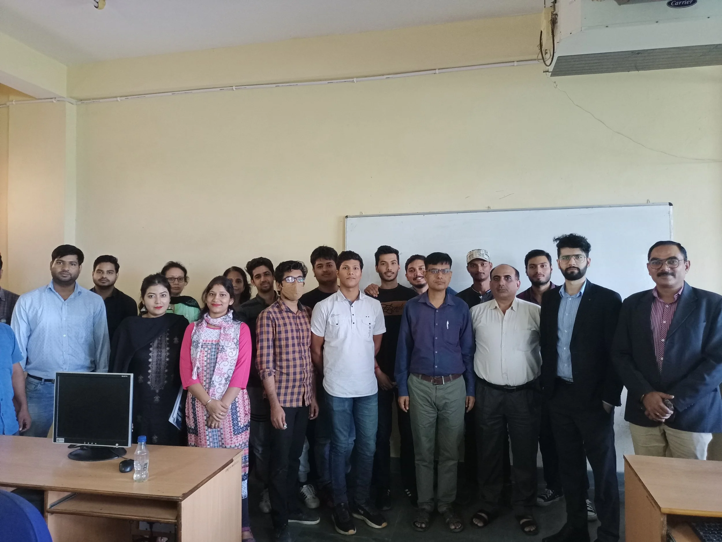 Group of people posing for a photo in a classroom